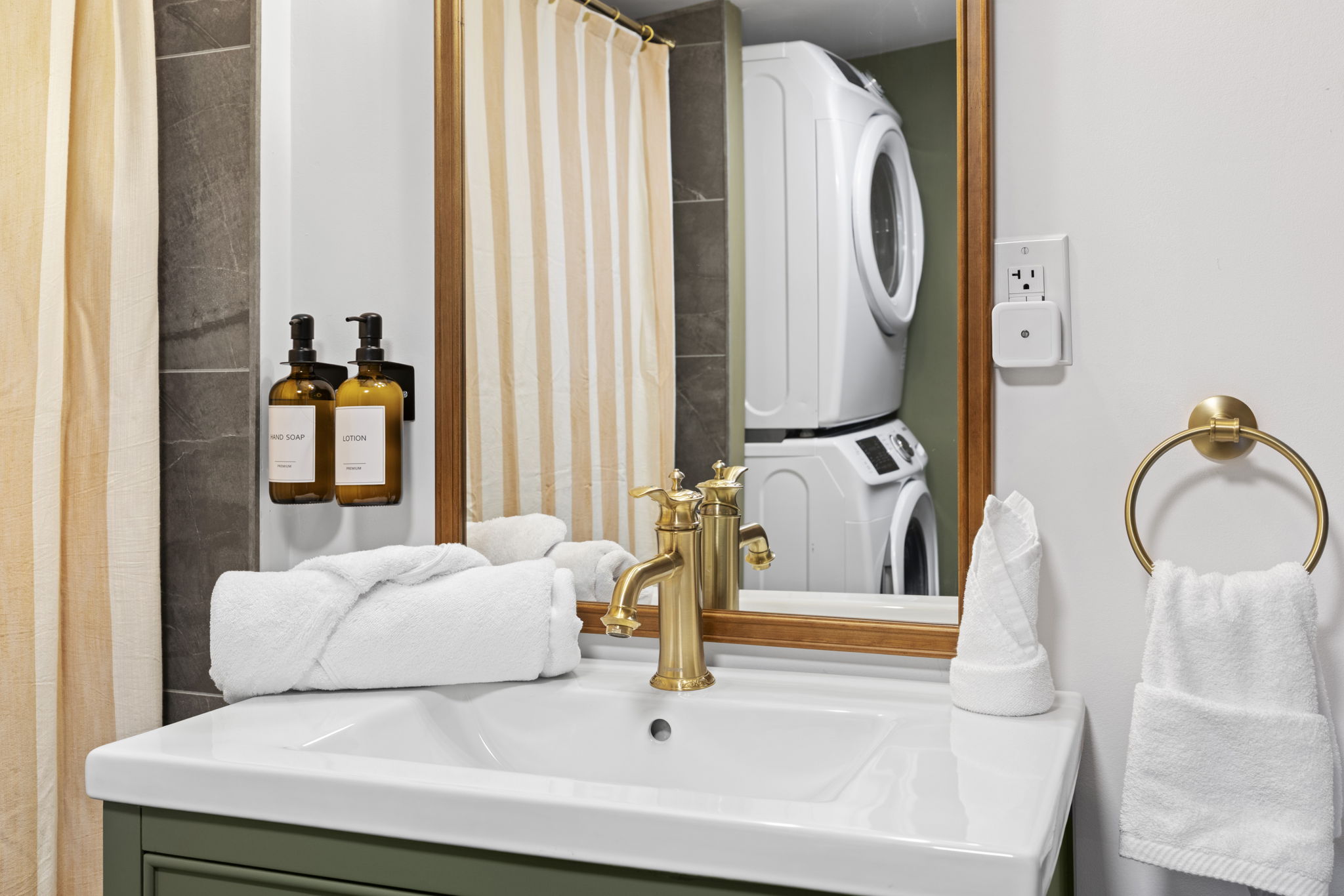 Modern bathroom with brass accents and convenient in-unit laundry