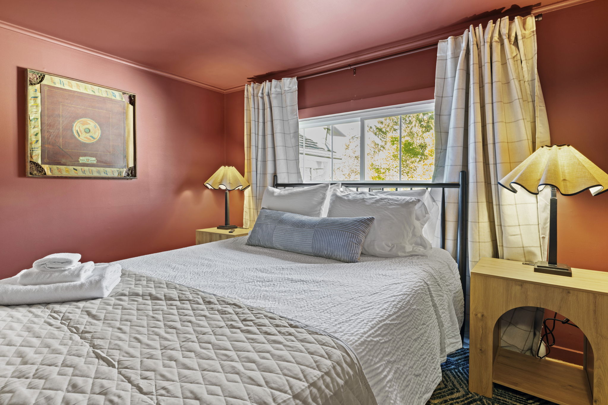 Cozy queen bedroom with warm tones, natural light, and guest-ready comfort