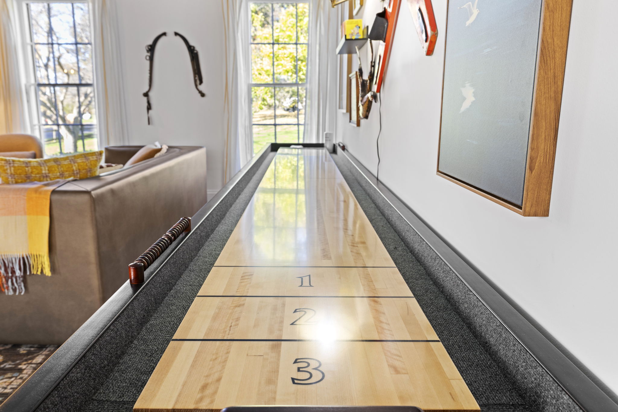 Bright lounge with shuffleboard table for fun, stylish indoor entertainment