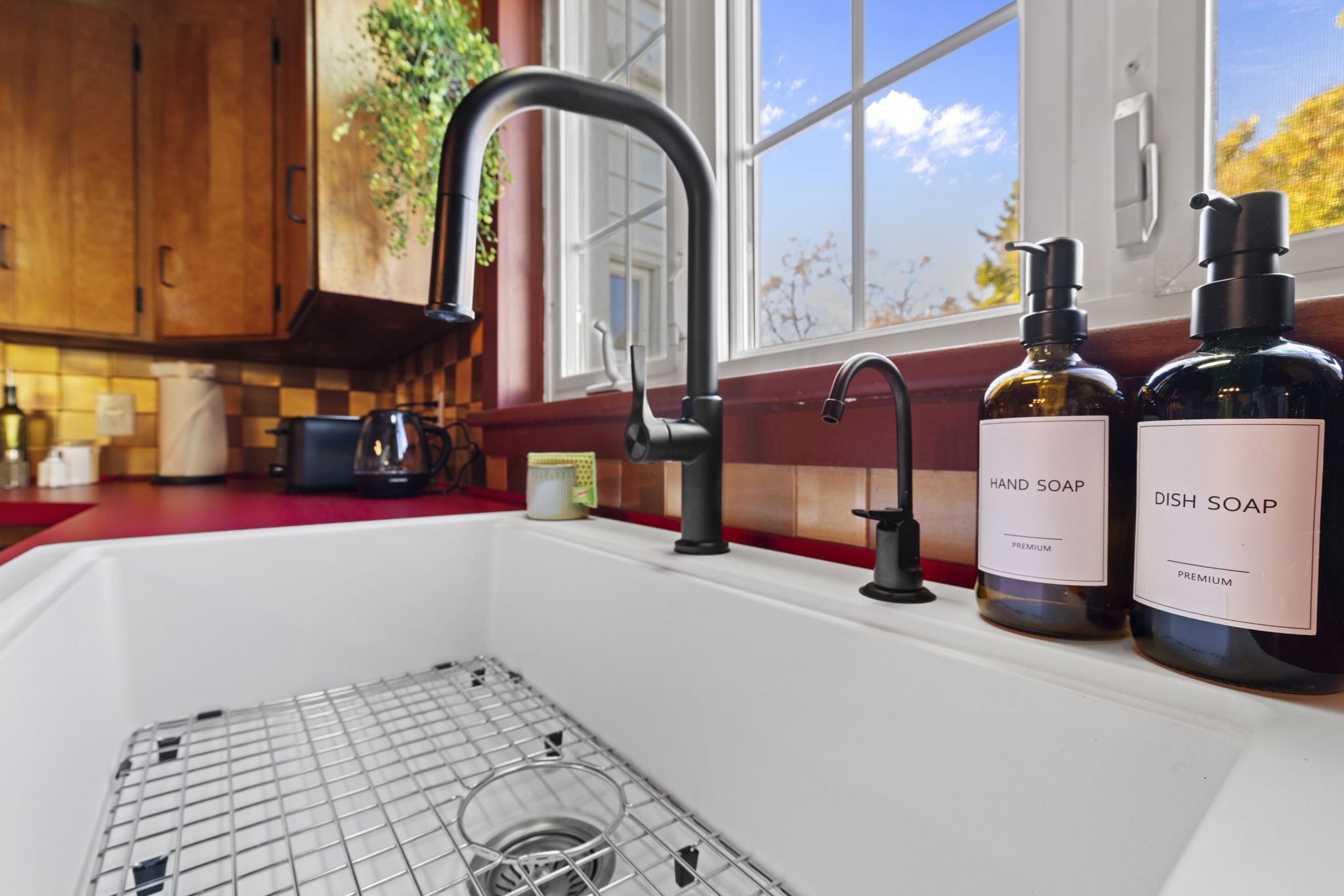Bright farmhouse sink with stylish black fixtures and sunny kitchen views