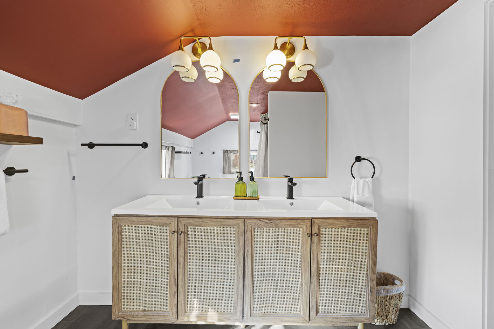 Chic double vanity with arched mirrors and a bold designer ceiling