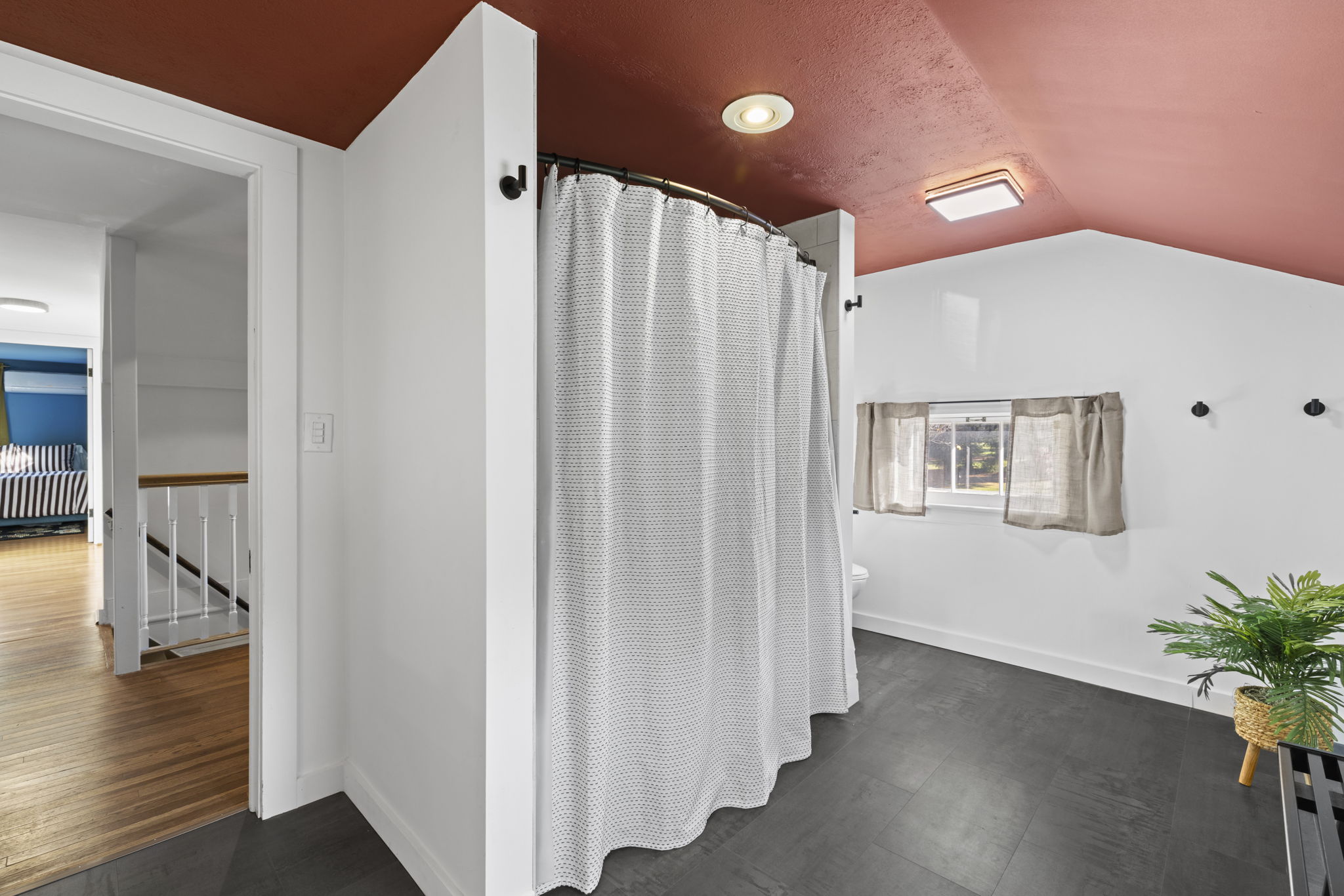 Spacious bathroom with unique curved shower and bright, airy feel