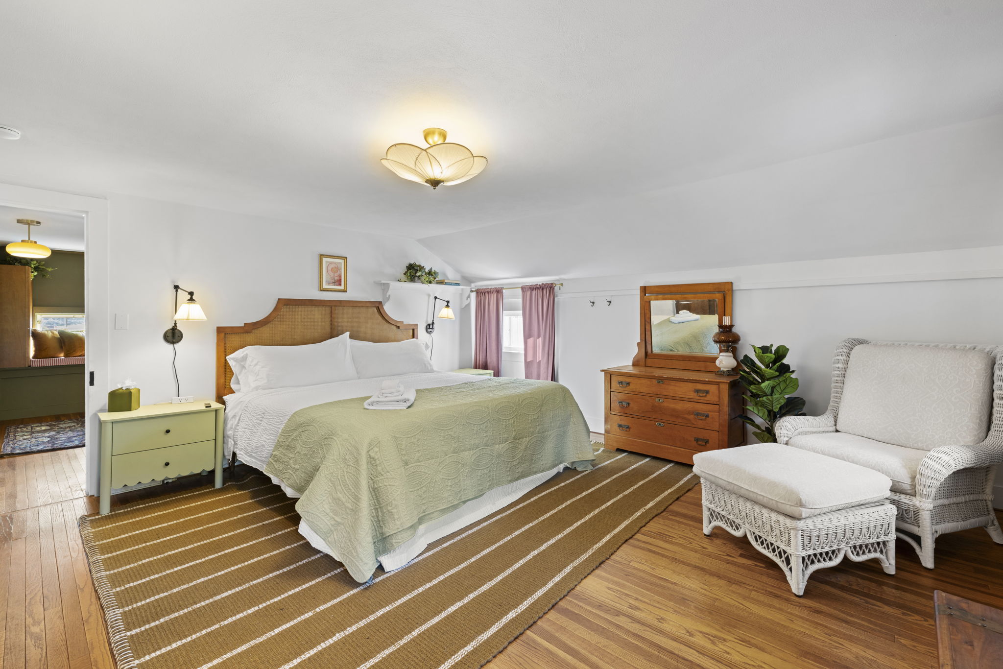 Spacious king bedroom with cozy seating and warm, inviting style