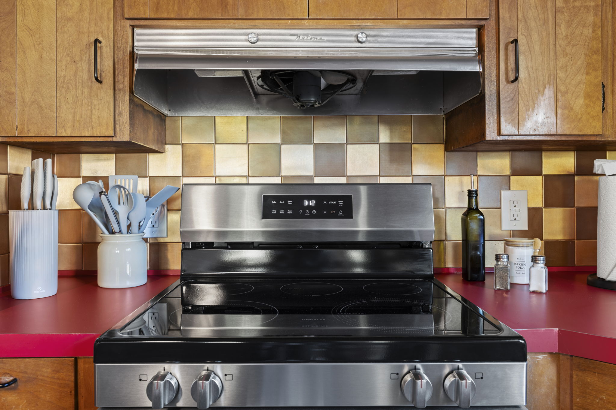Stylish kitchen with stainless range, vent hood, and bold designer finishes