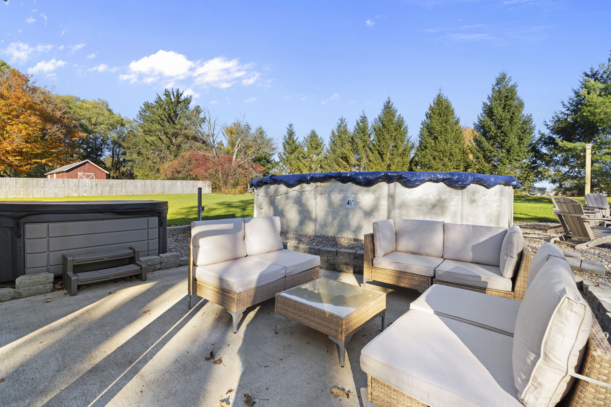 Relax on the sunny patio with lounge seating, pool access, and hot tub