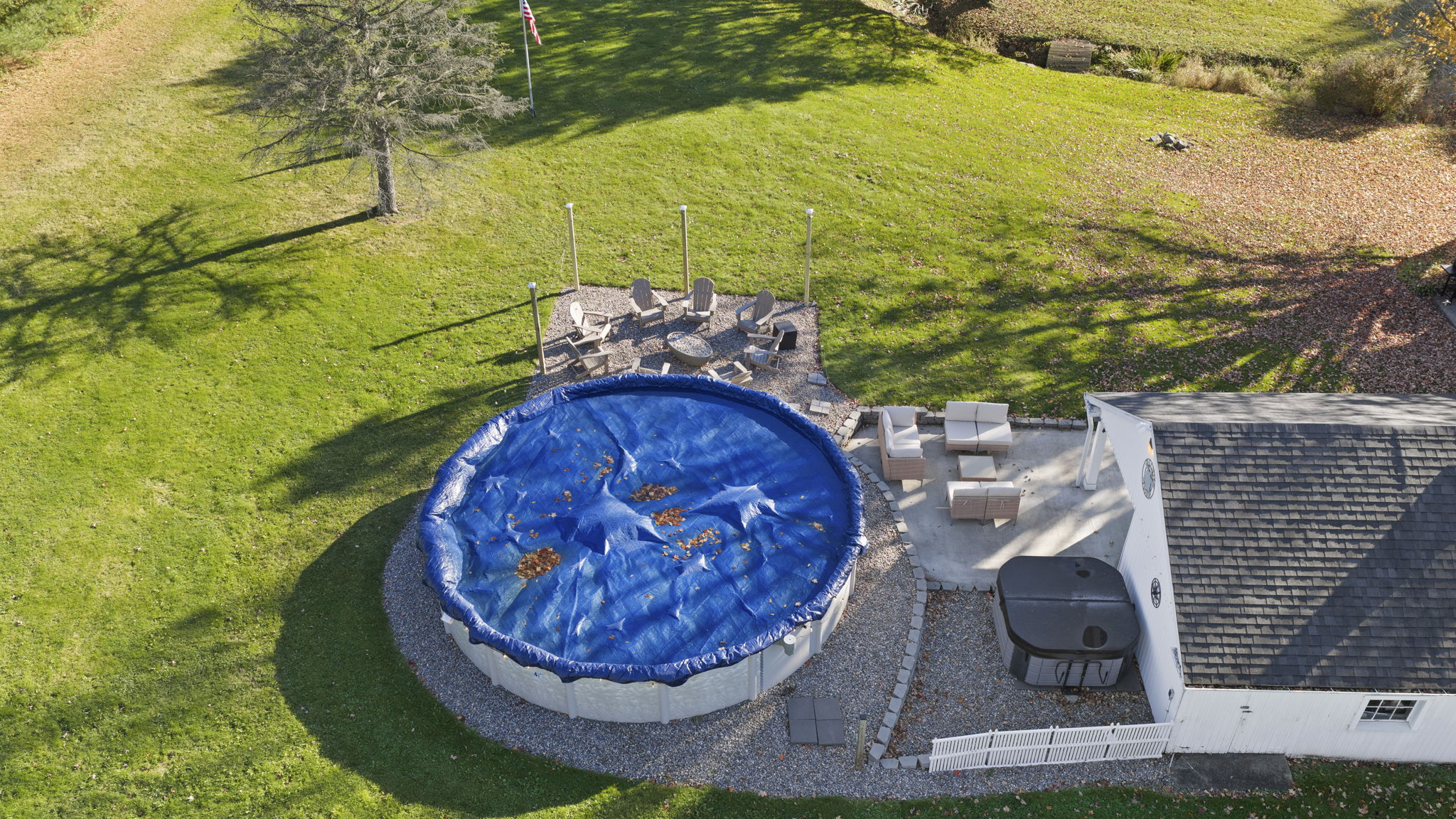 Spacious backyard with hot tub, patio seating, and seasonal pool