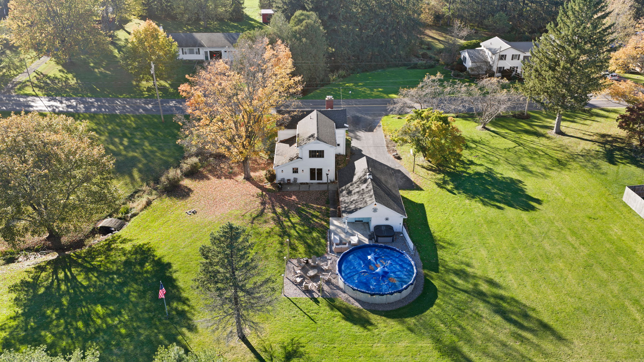 Spacious backyard retreat with pool, deck, and peaceful green surroundings