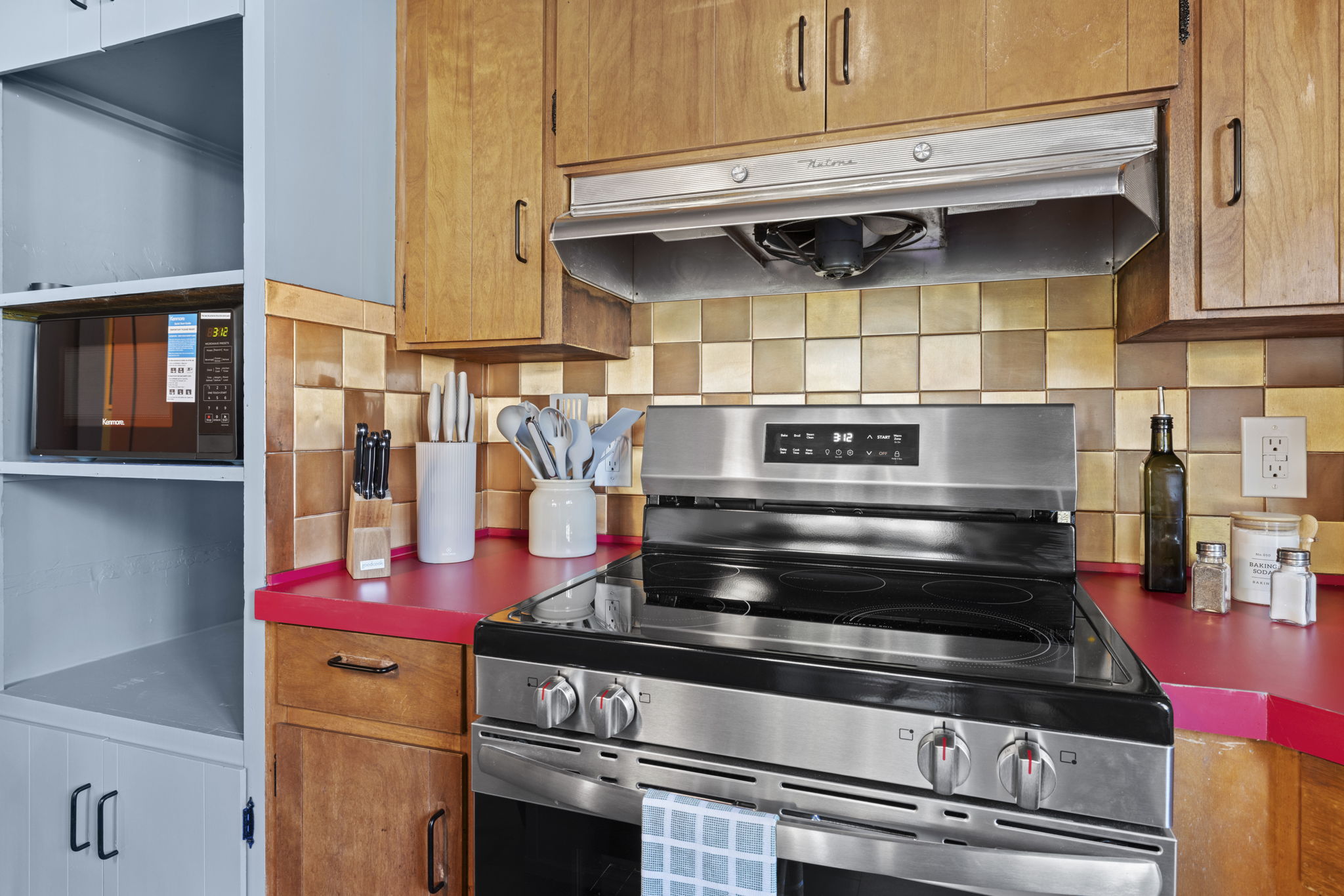 Well-equipped kitchen with stainless range and bold, colorful counters