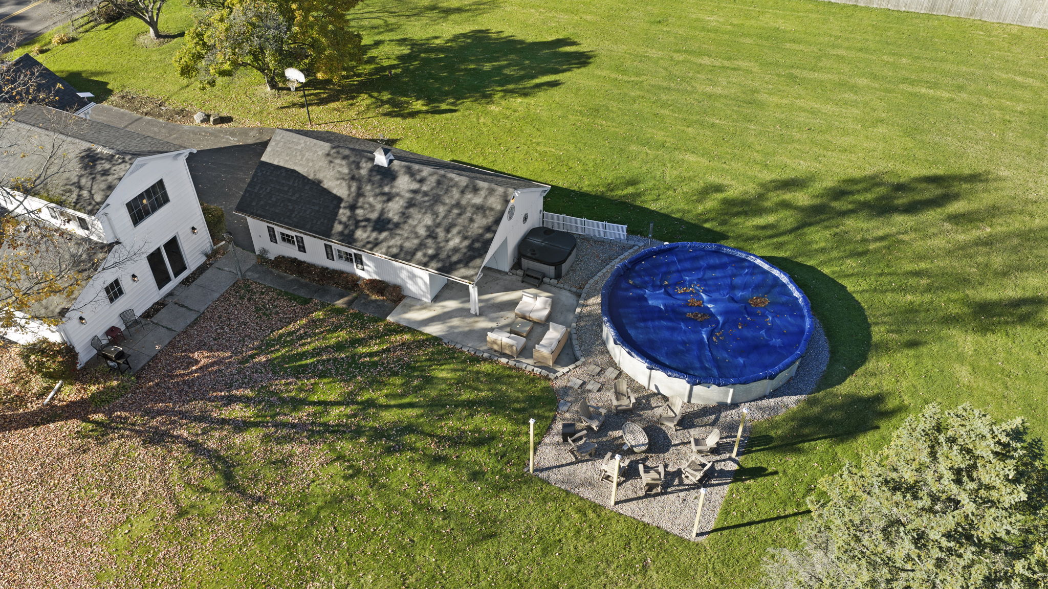 Spacious backyard with pool, patio seating, and open green space
