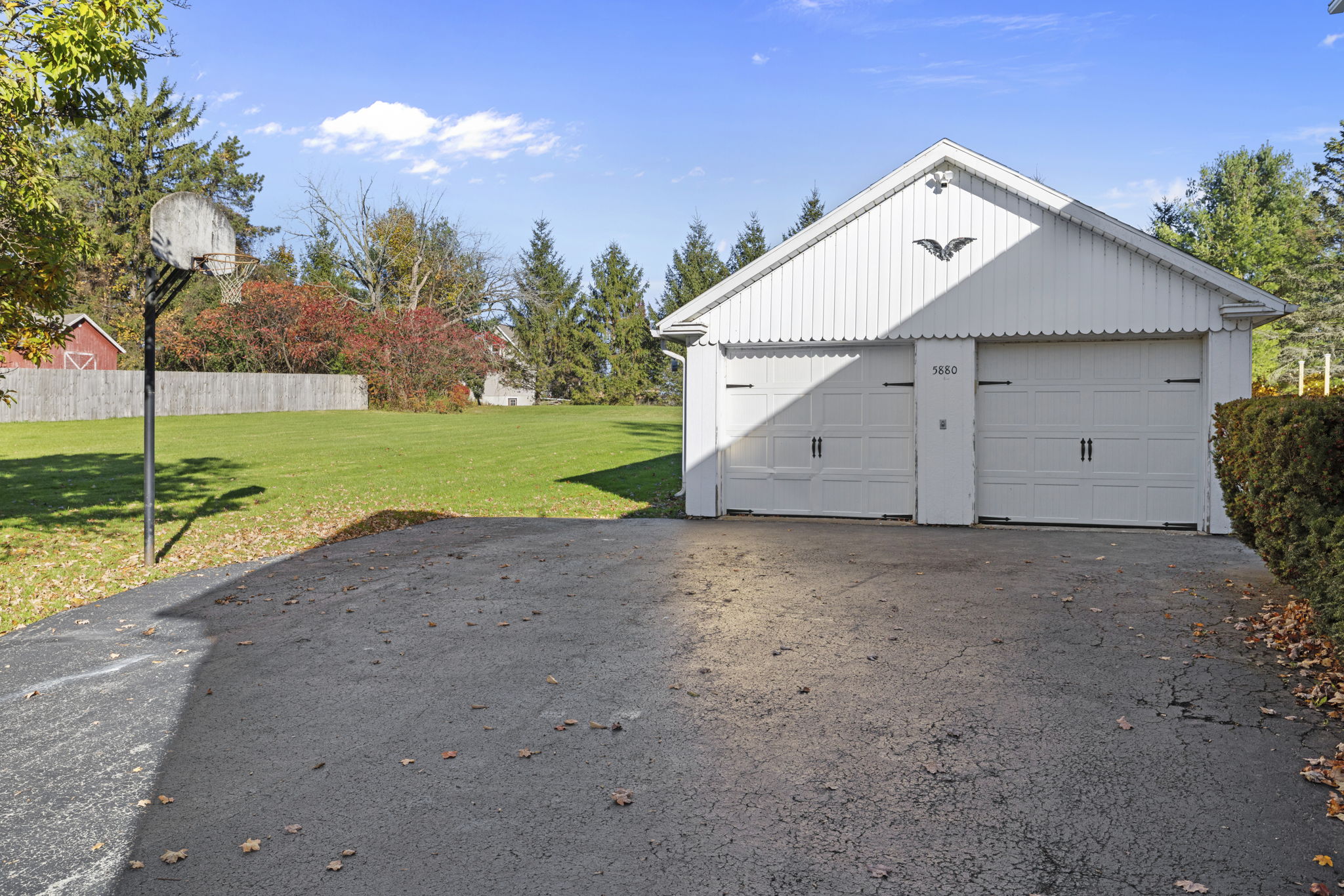 Spacious driveway, 2-car garage, and large yard with basketball hoop