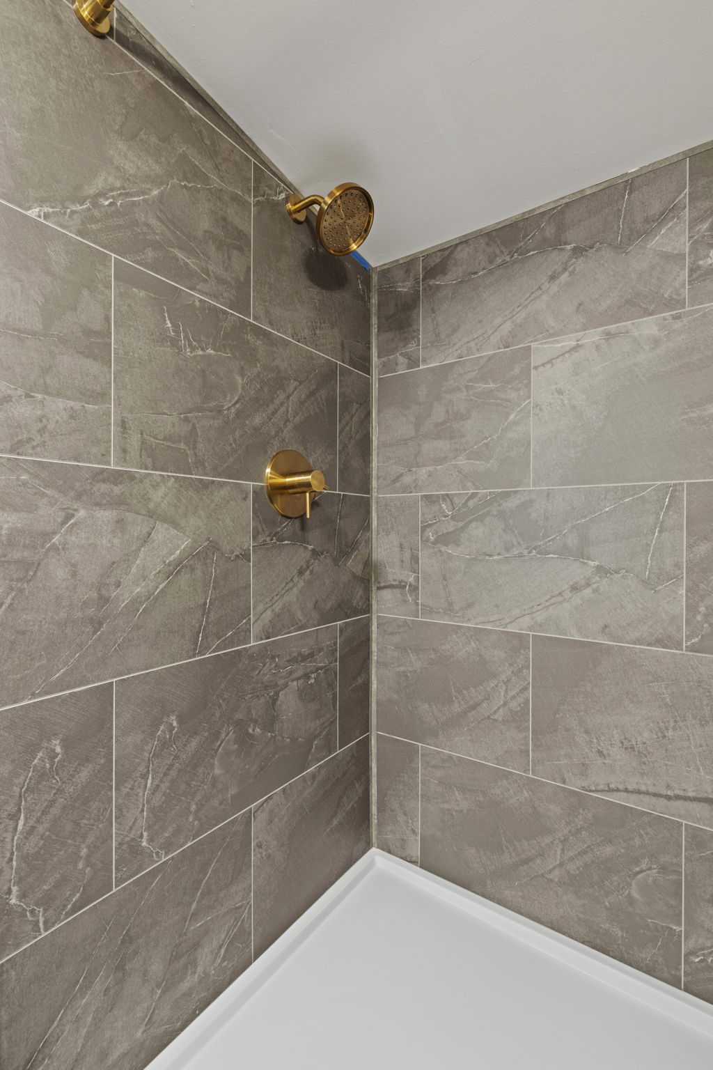 Modern tiled shower with sleek brass fixtures and a spa-like feel