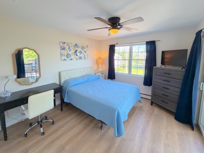 Bright, airy bedroom with workspace, TV, and plenty of natural light