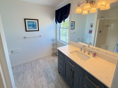 Bright modern bathroom with large vanity, walk-in shower, and natural light