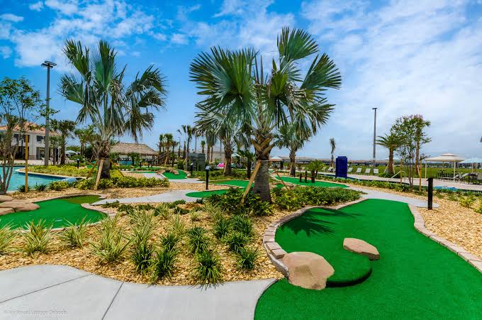 Resort-style mini golf surrounded by palms and sunny tropical landscaping