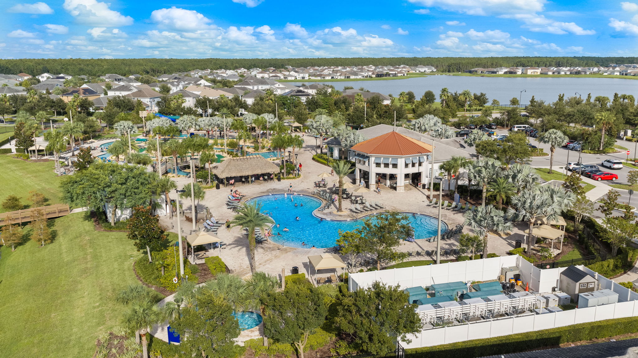 Resort-style pool, clubhouse, and tropical amenities near the lake