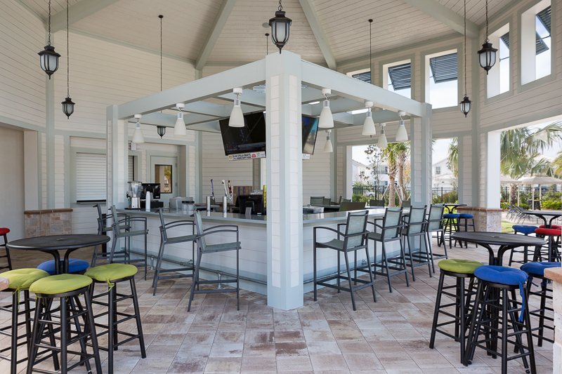 Bright open-air pavilion bar with TVs, high-top seating, and resort vibes