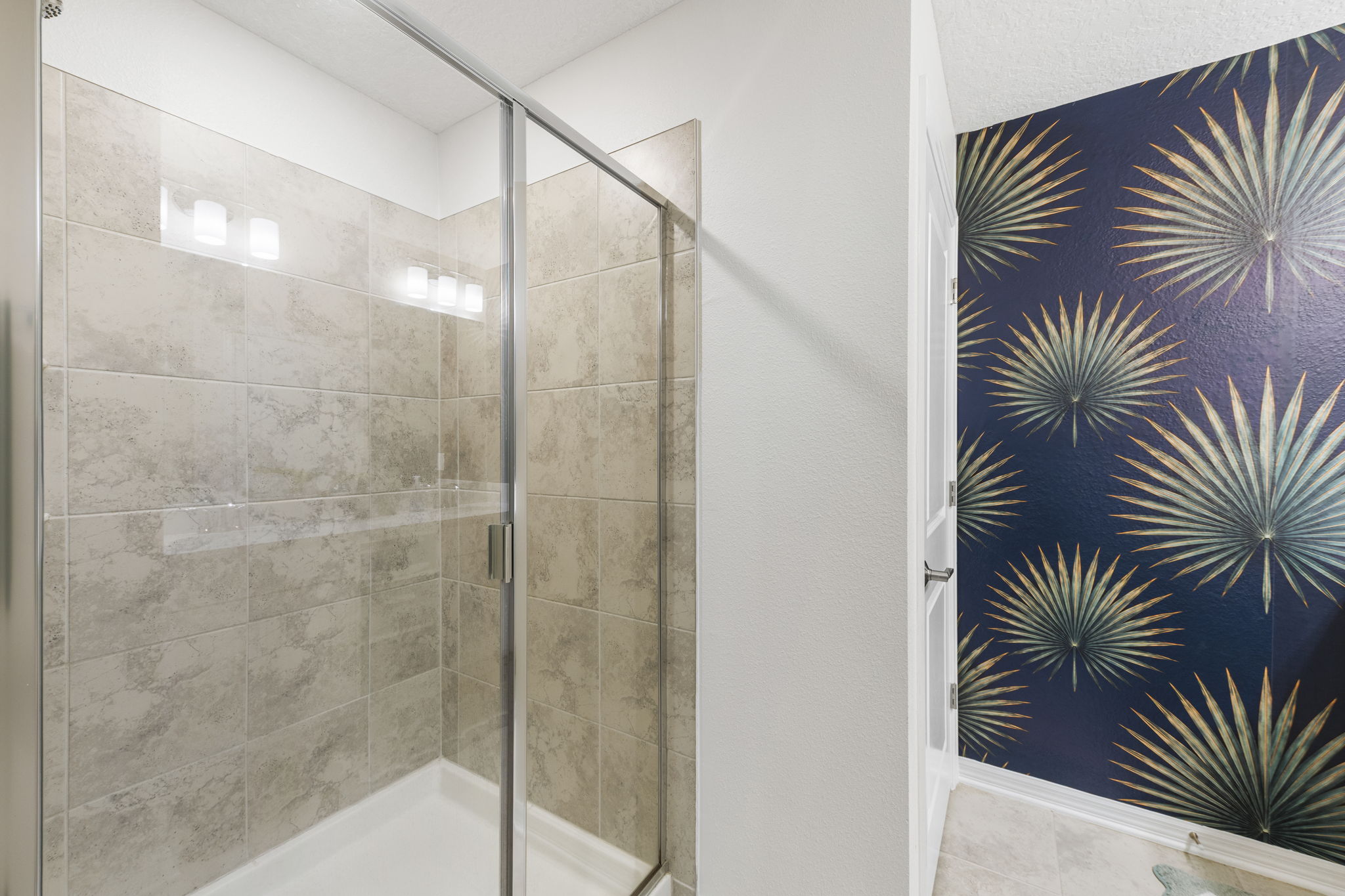 Stylish bath with glass walk-in shower and bold designer accent wall