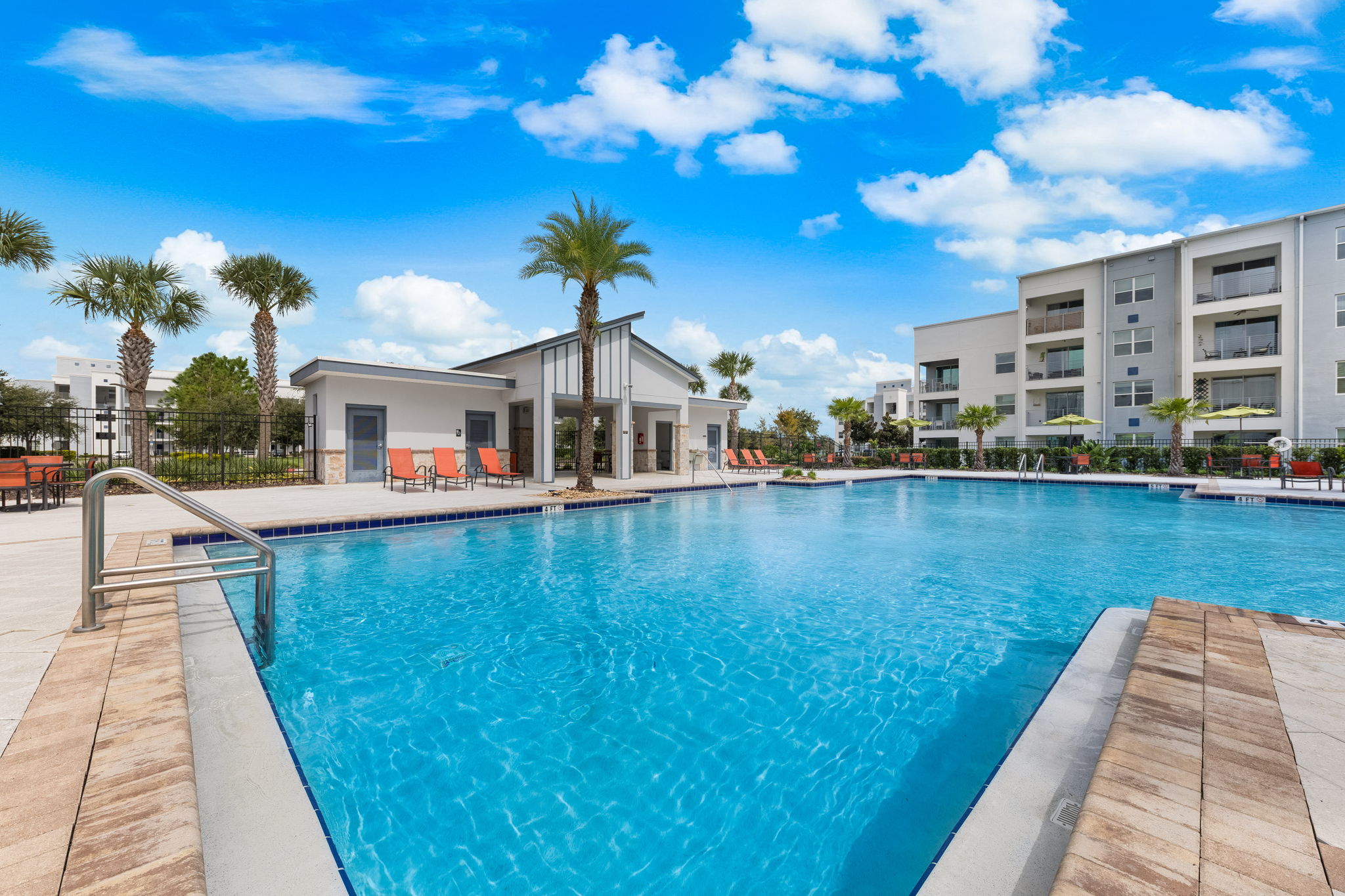 Resort-style pool oasis with palm trees and modern lounge areas