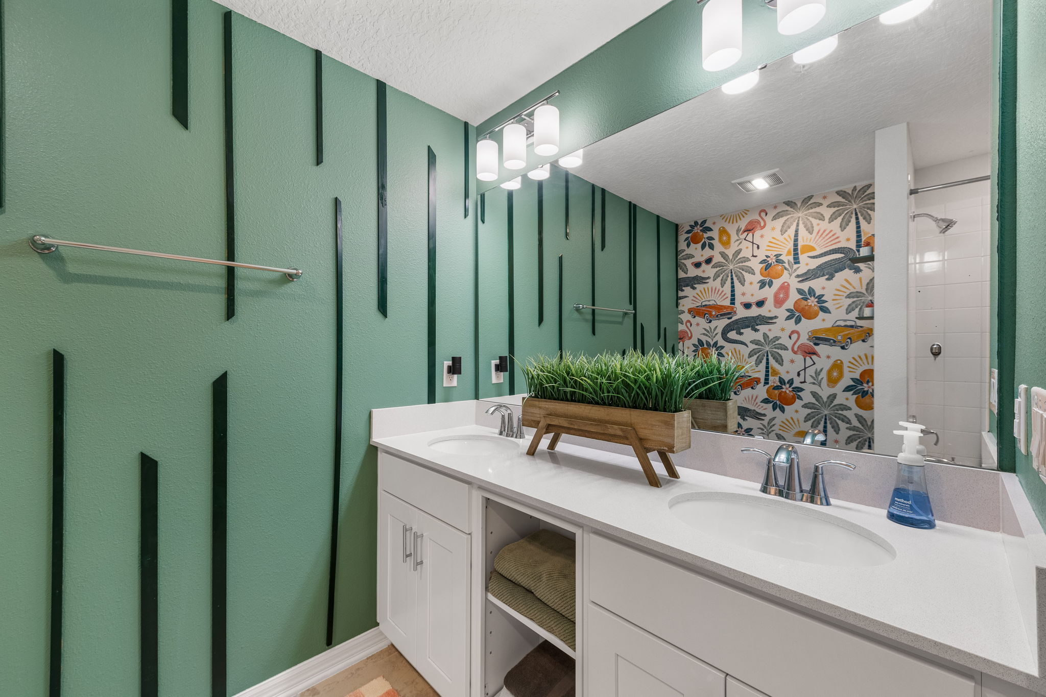 Stylish double-vanity bathroom with bold green walls and tropical flair