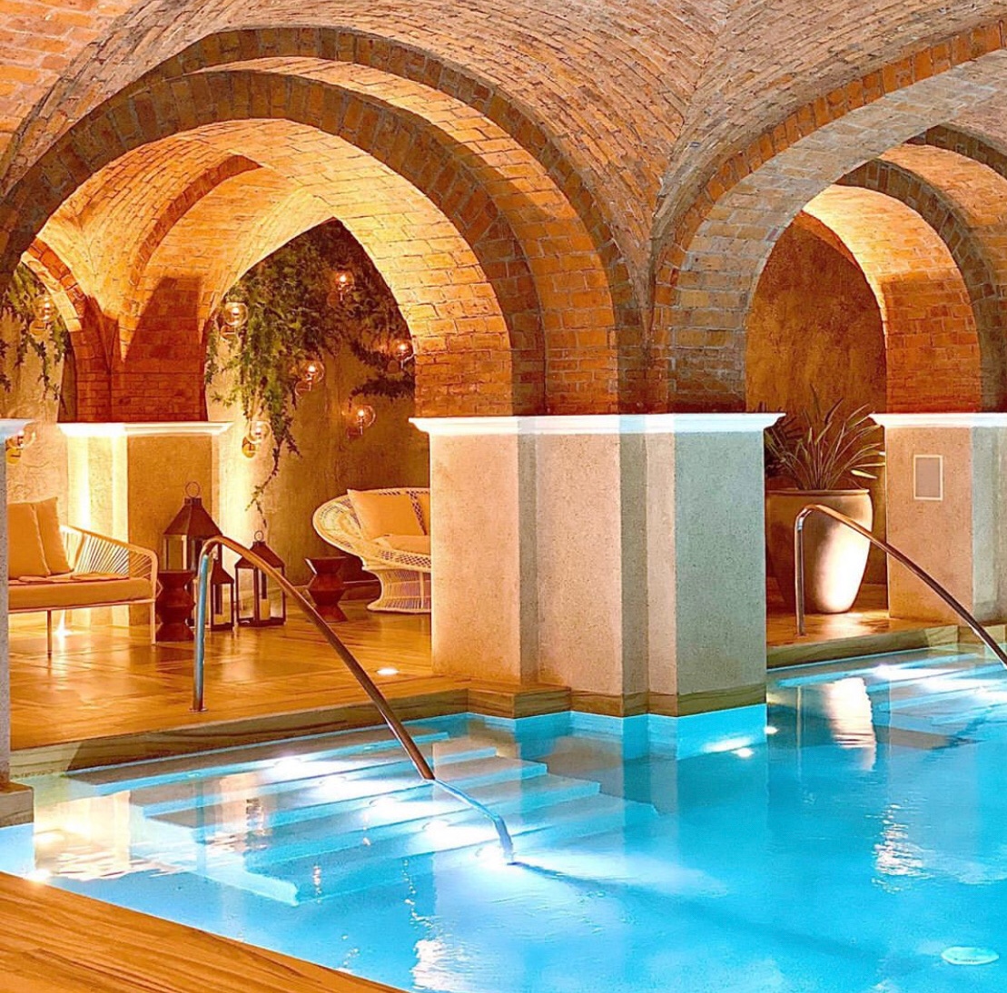 Elegant indoor spa pool beneath vaulted brick arches