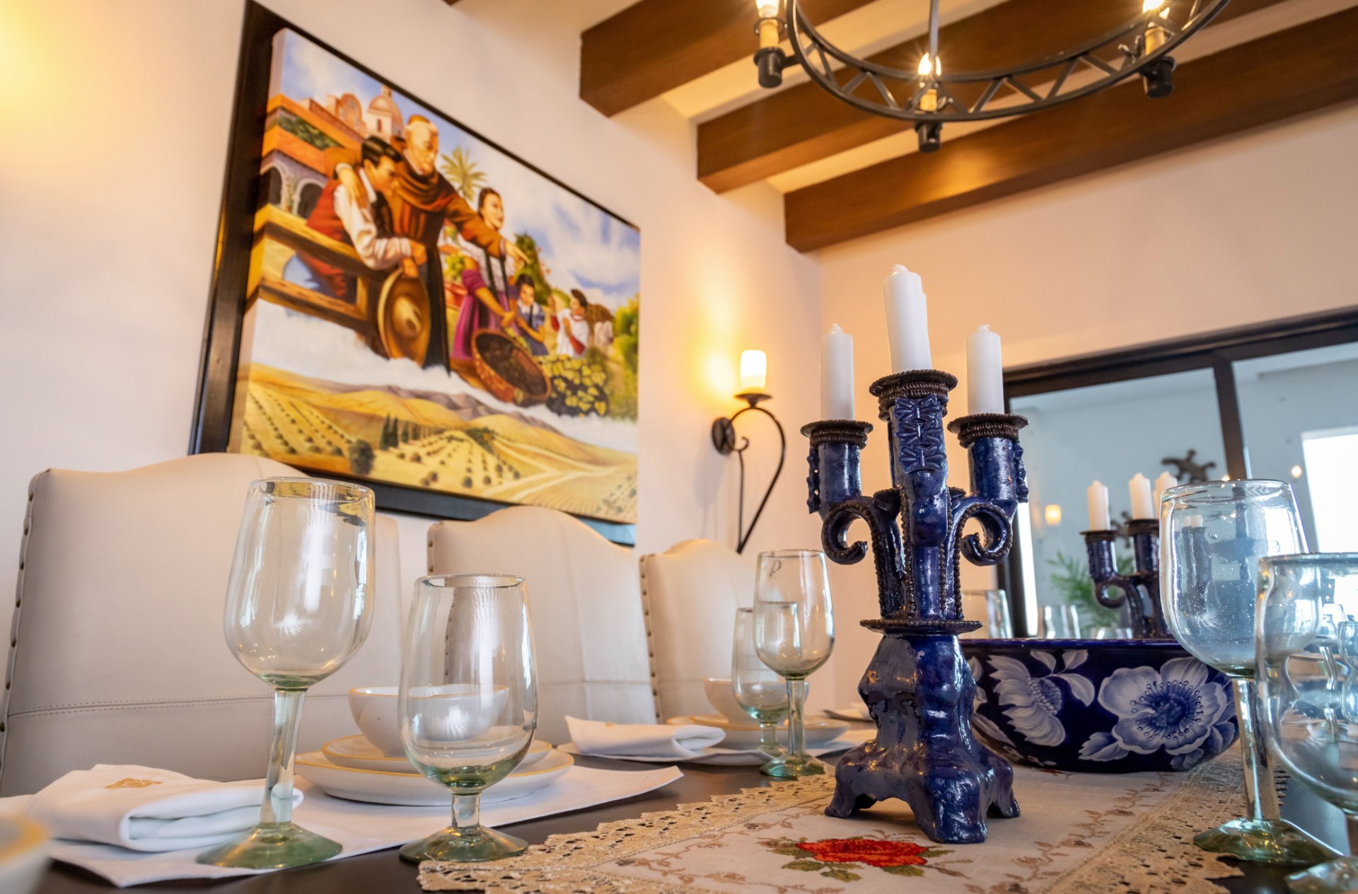 Elegant dining room with rustic beams, art, and a beautifully set table
