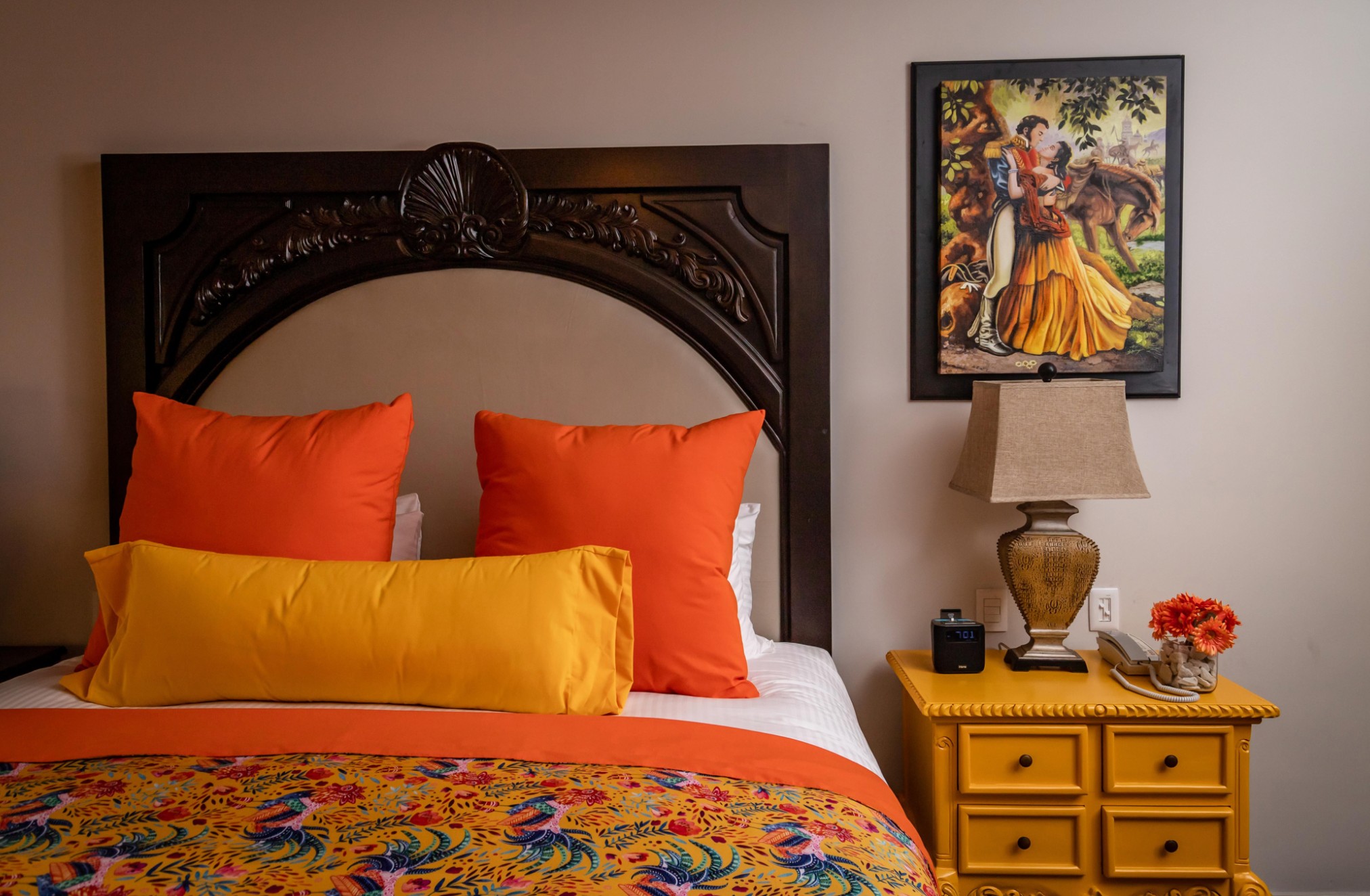Vibrant, cozy bedroom with bold accents and elegant carved headboard