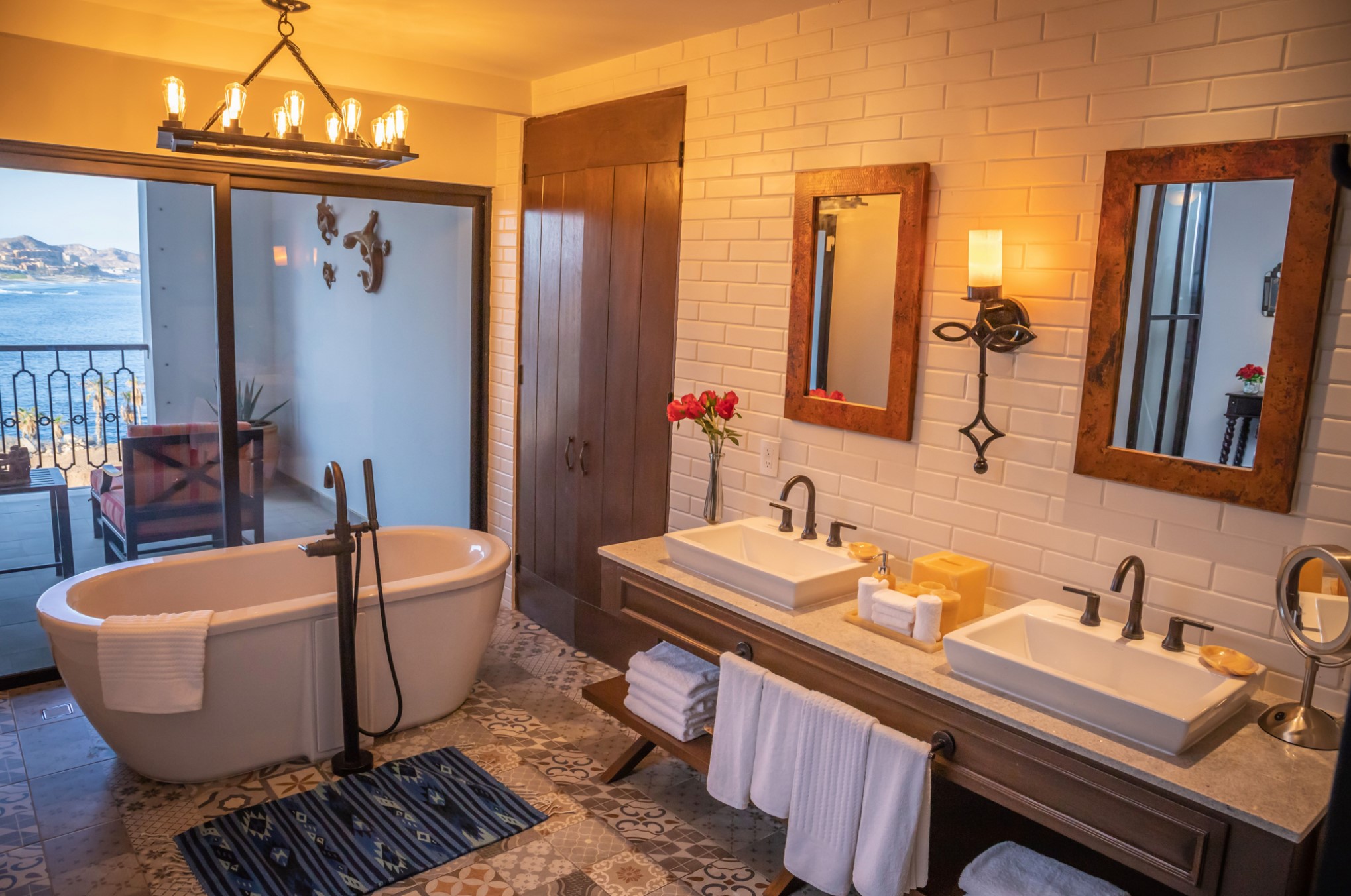 Spa-style bathroom with soaking tub, double vanity, and water-view balcony