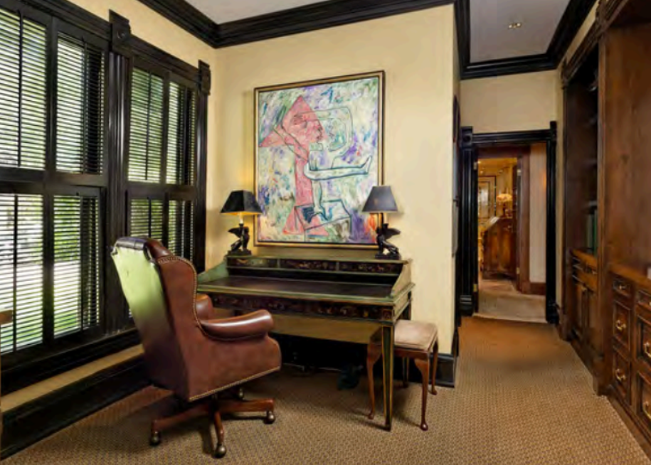 Elegant private study with leather chair, artwork, and classic wood details