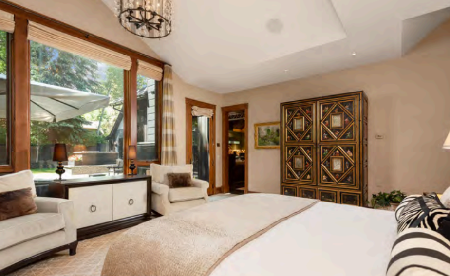 Bright, elegant bedroom with patio views and cozy seating