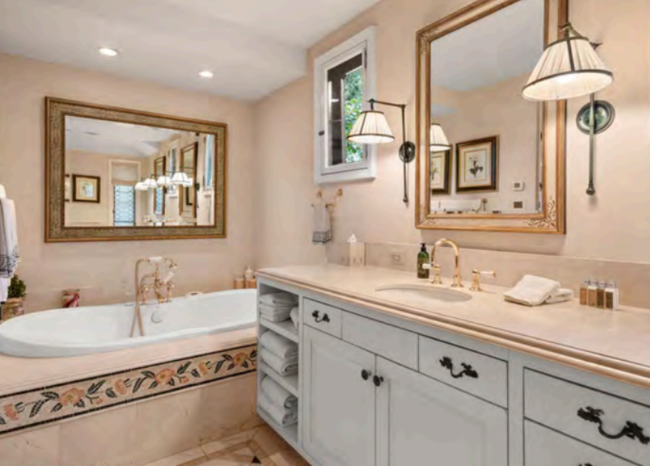 Spa-like bathroom with double vanity, soaking tub, and elegant lighting