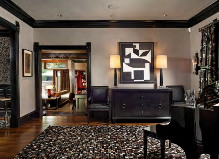 Elegant living space with piano, bold decor, and warm designer finishes