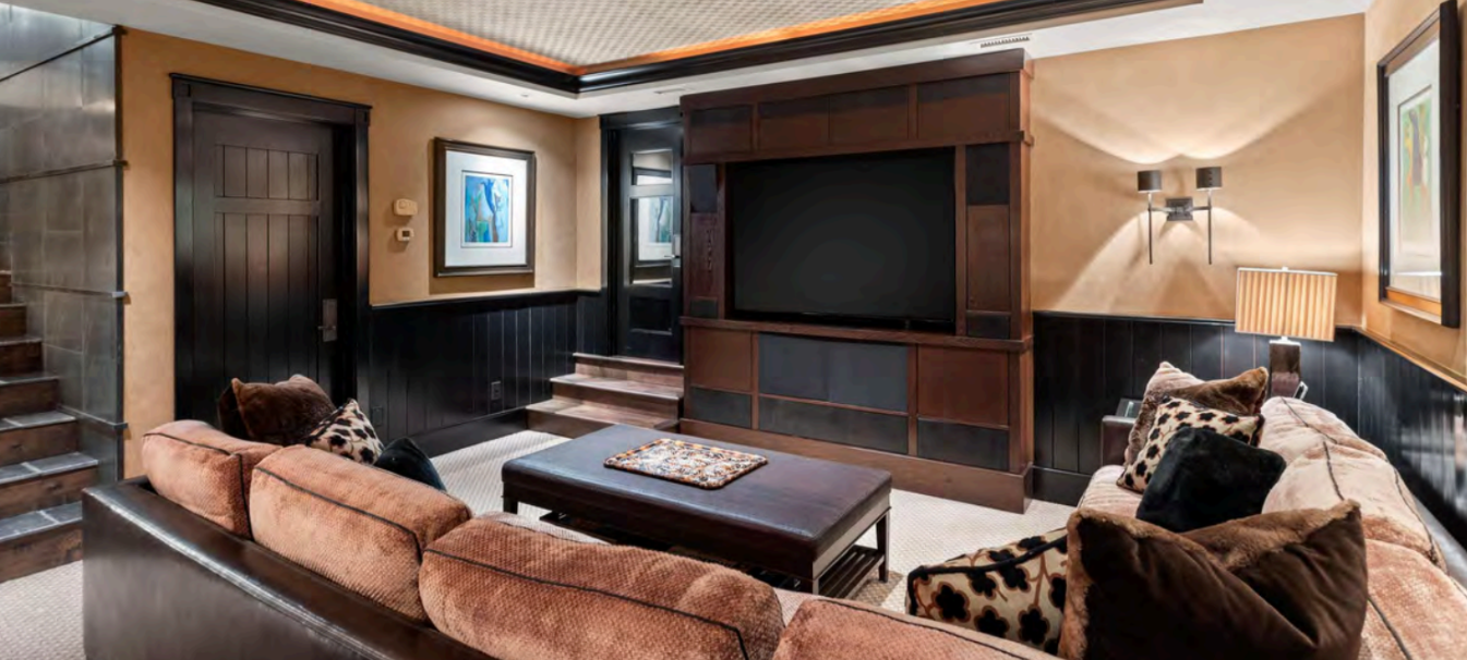 Cozy media room with plush seating and a large built-in TV