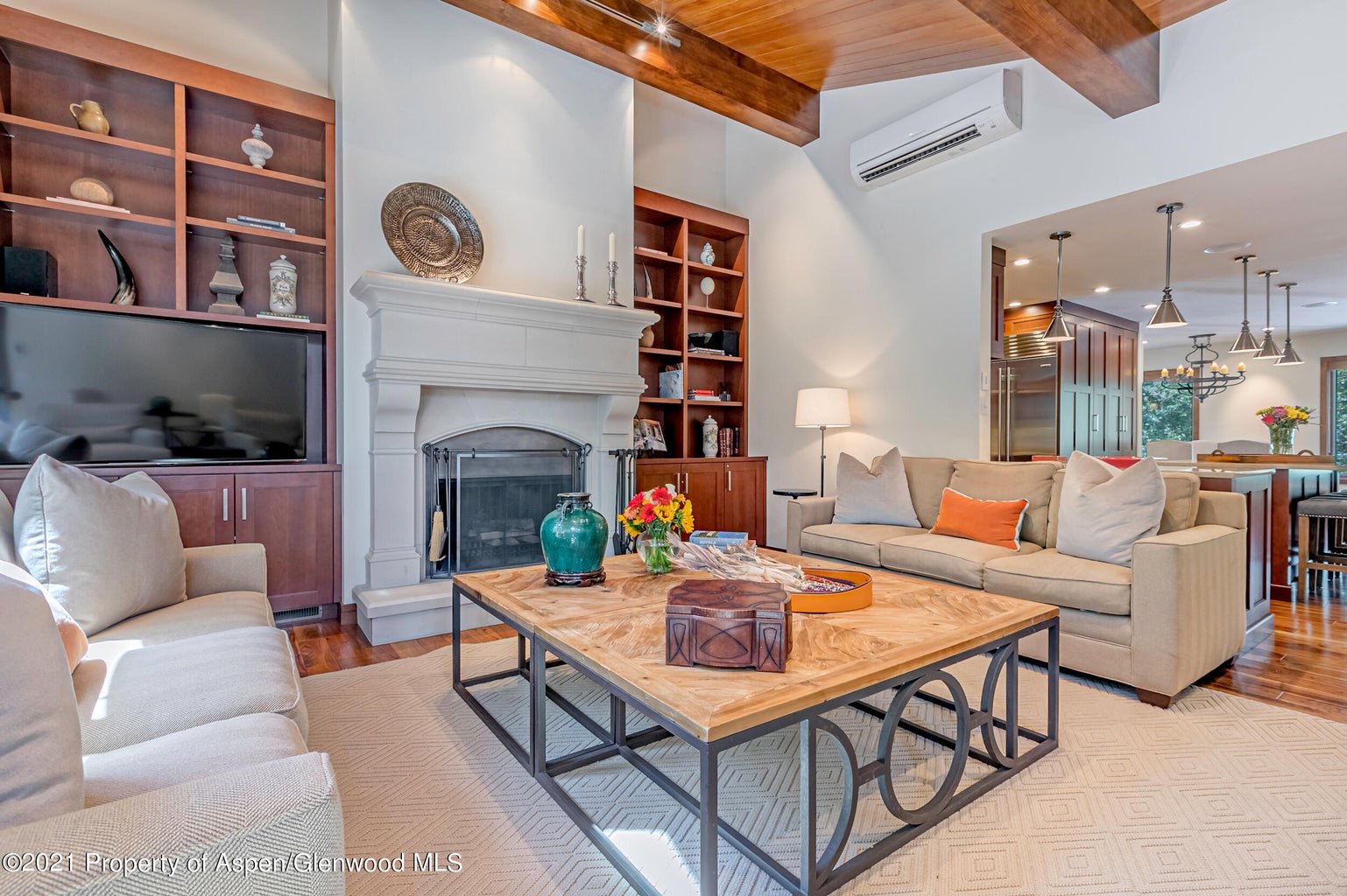 Bright vaulted living room with fireplace and open kitchen