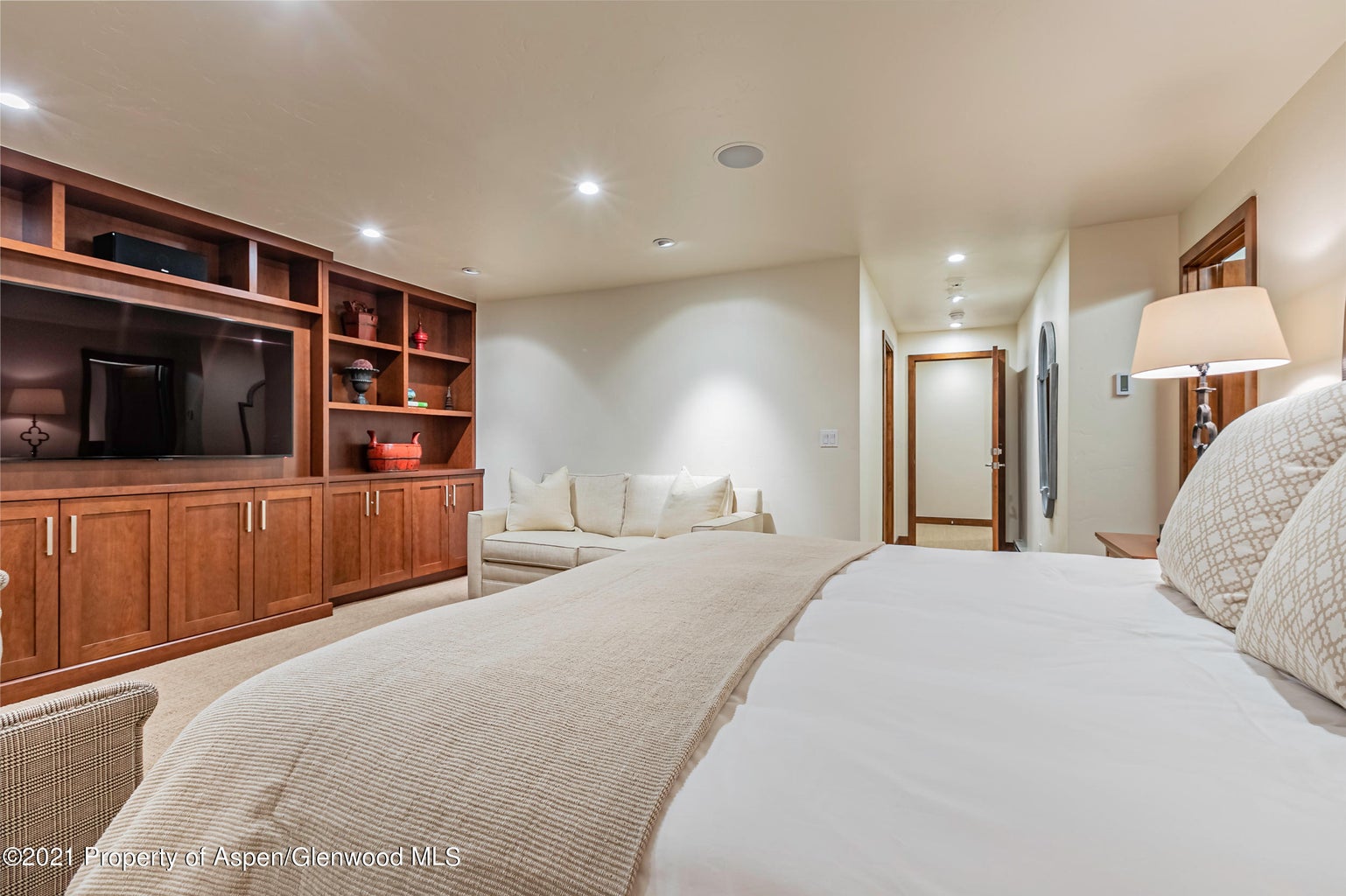 Spacious suite with built-ins, TV, and cozy sitting area