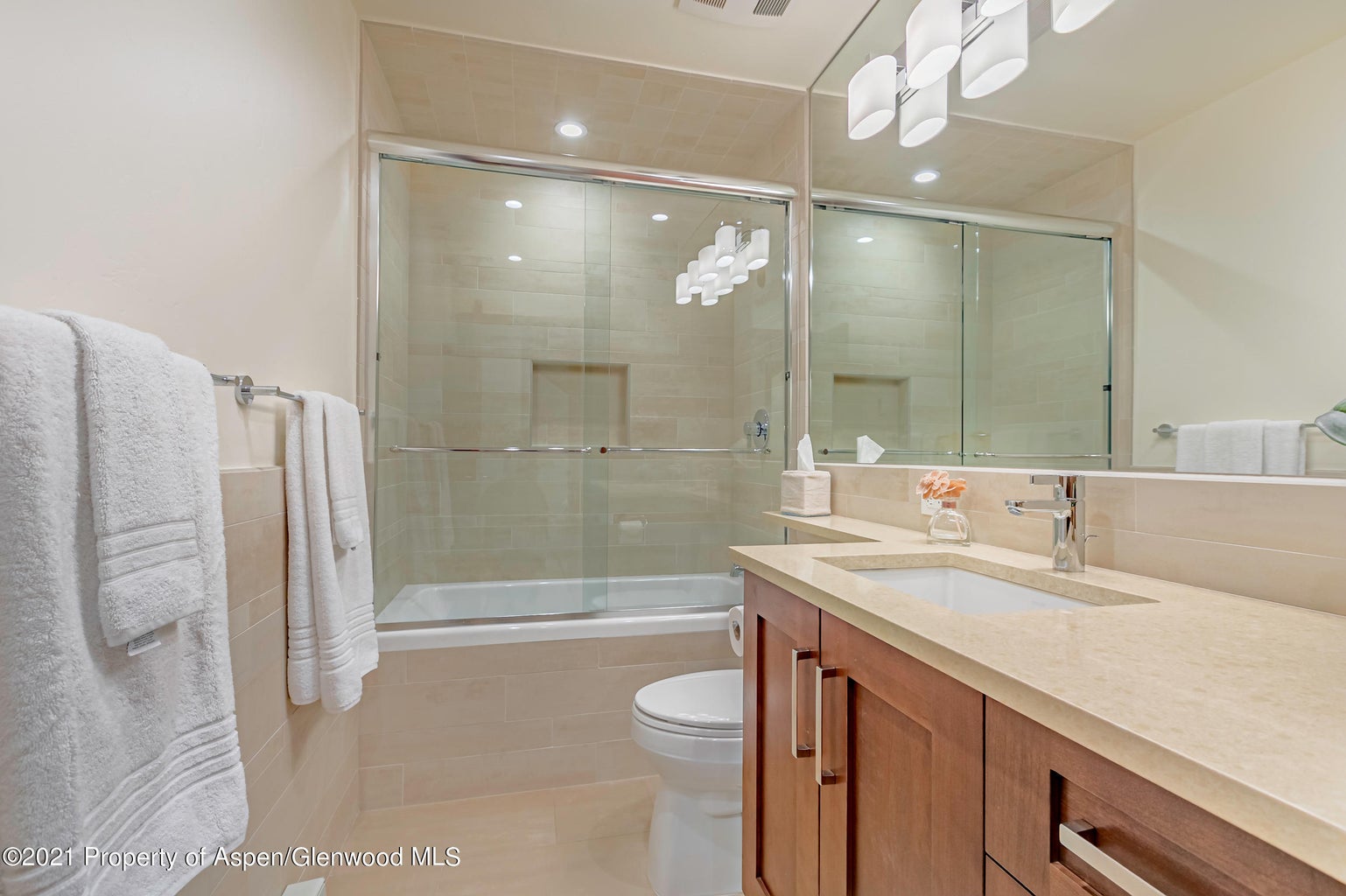 Bright modern bathroom with glass shower-tub and sleek vanity