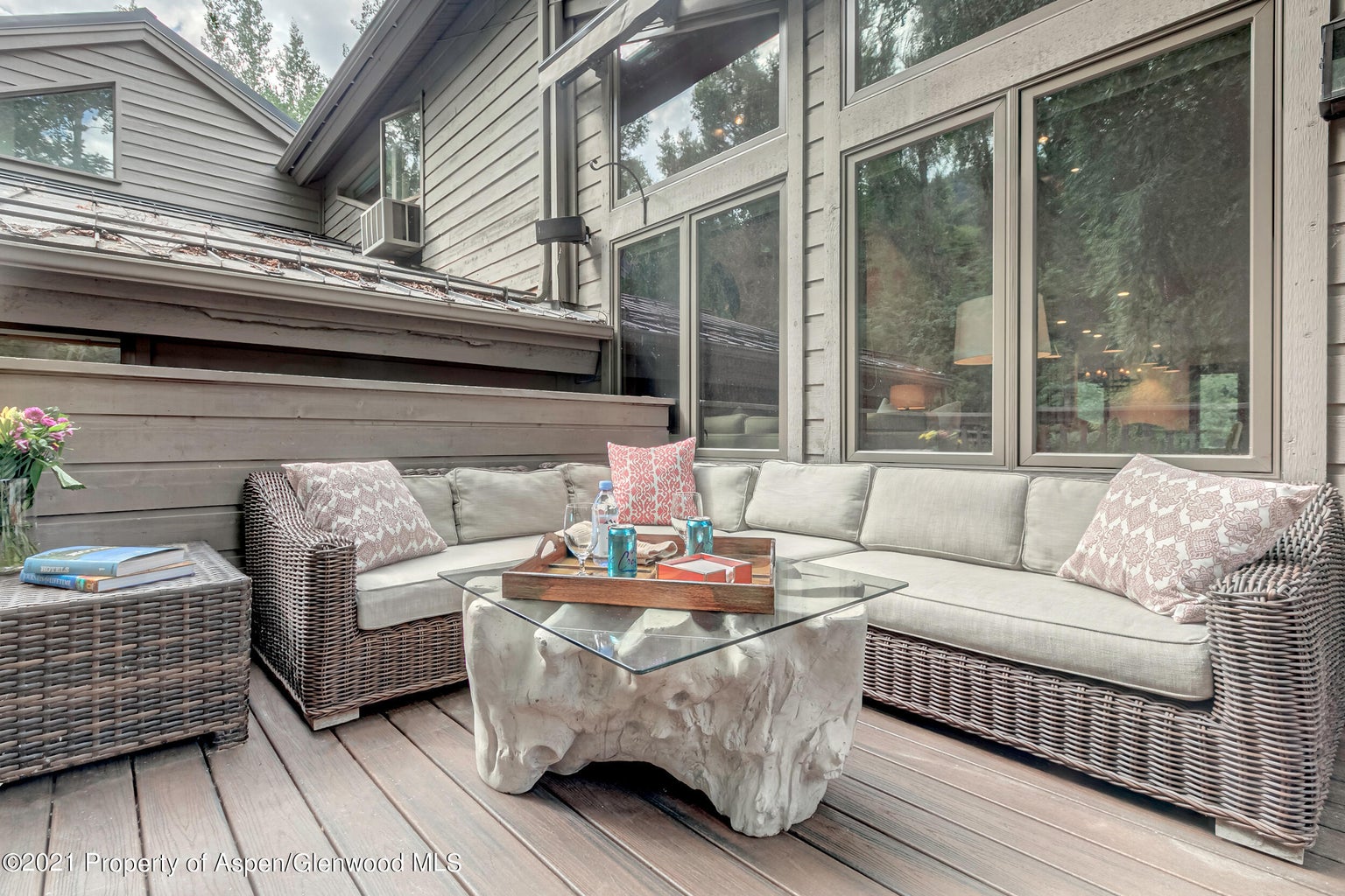 Private deck with cushioned sectional and serene wooded surroundings