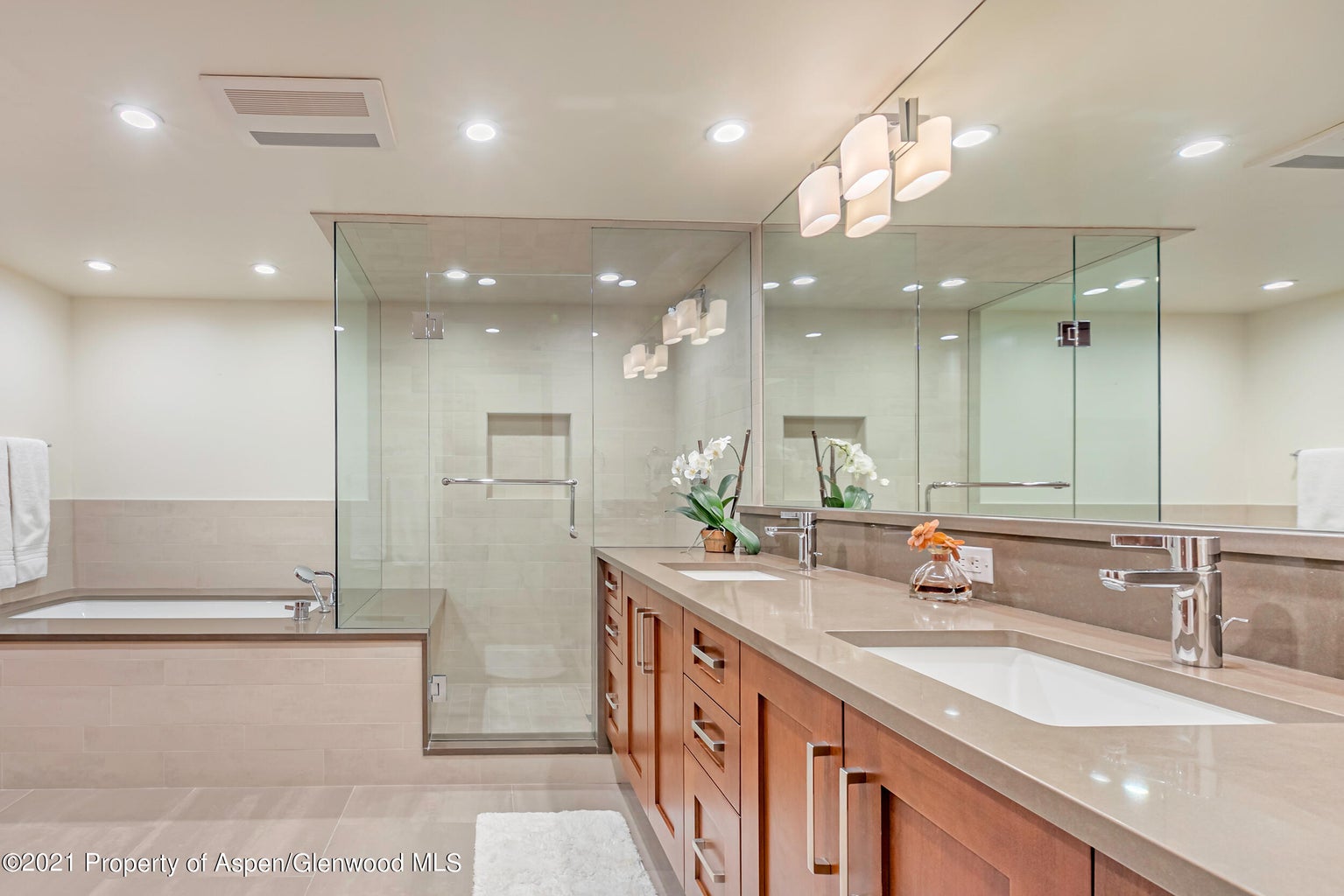 Spa-style bath with double vanity, soaking tub, and glass walk-in shower
