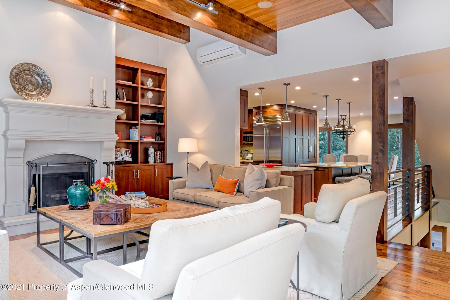 Cozy great room with fireplace, wood beams, and open gourmet kitchen