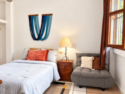 Bright, cozy bedroom with reading chair and natural light