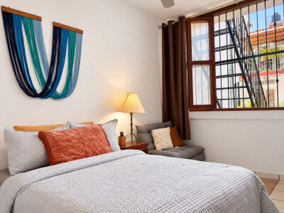 Bright, cozy bedroom with reading nook and large sunlit window