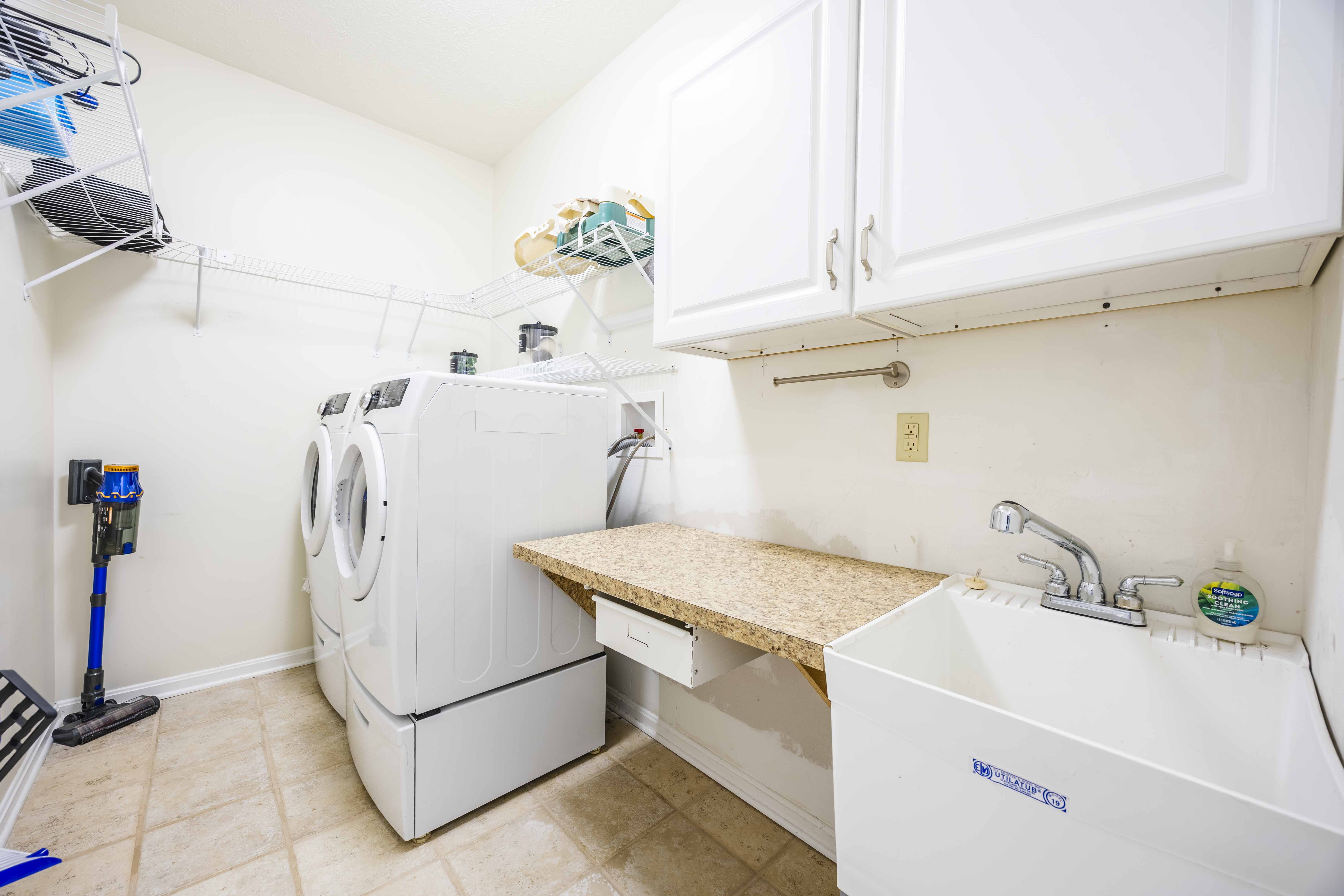 Bright laundry room with full-size washer/dryer and folding counter