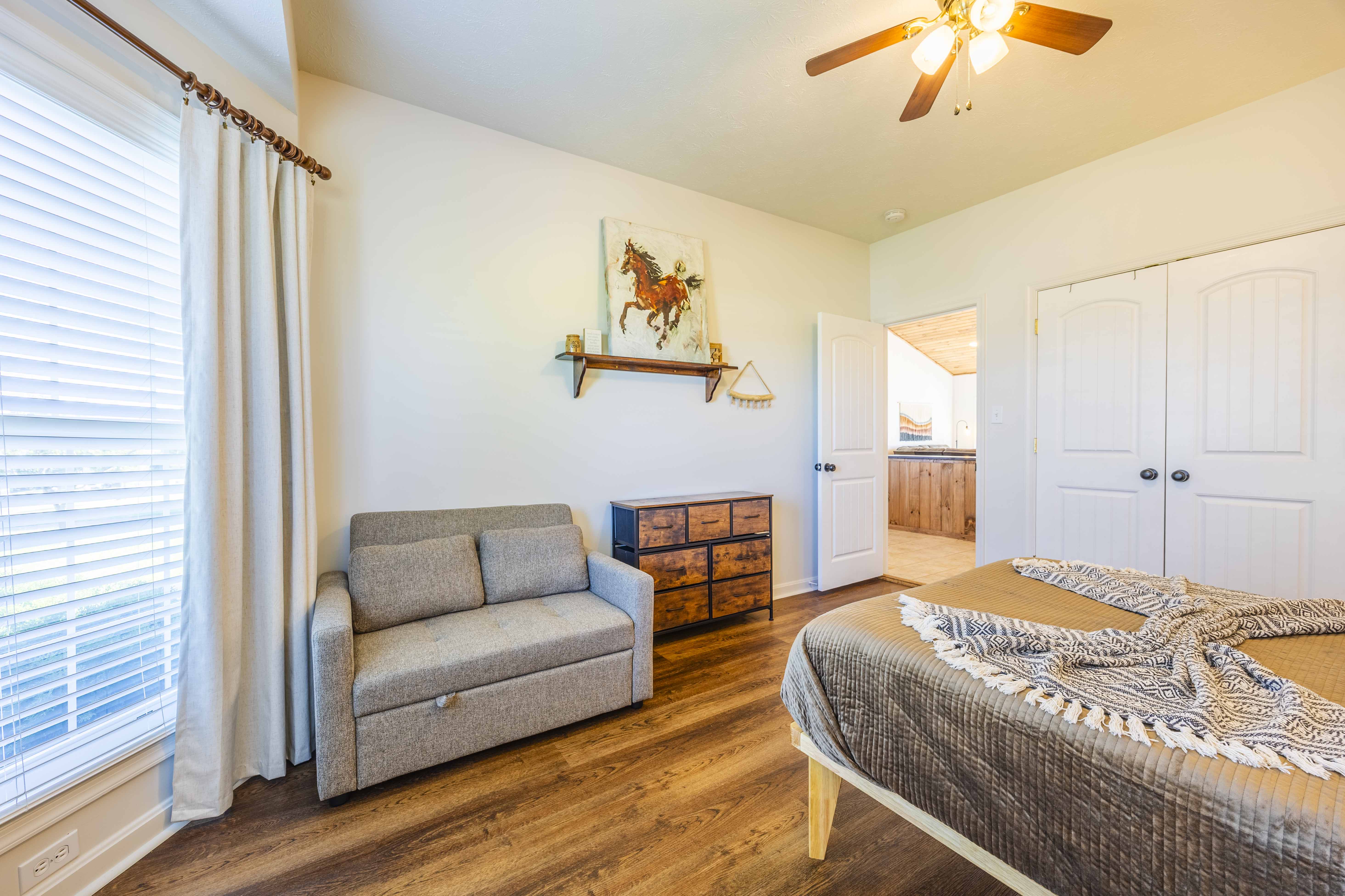 Bright bedroom with cozy loveseat, rustic touches, and plenty of space