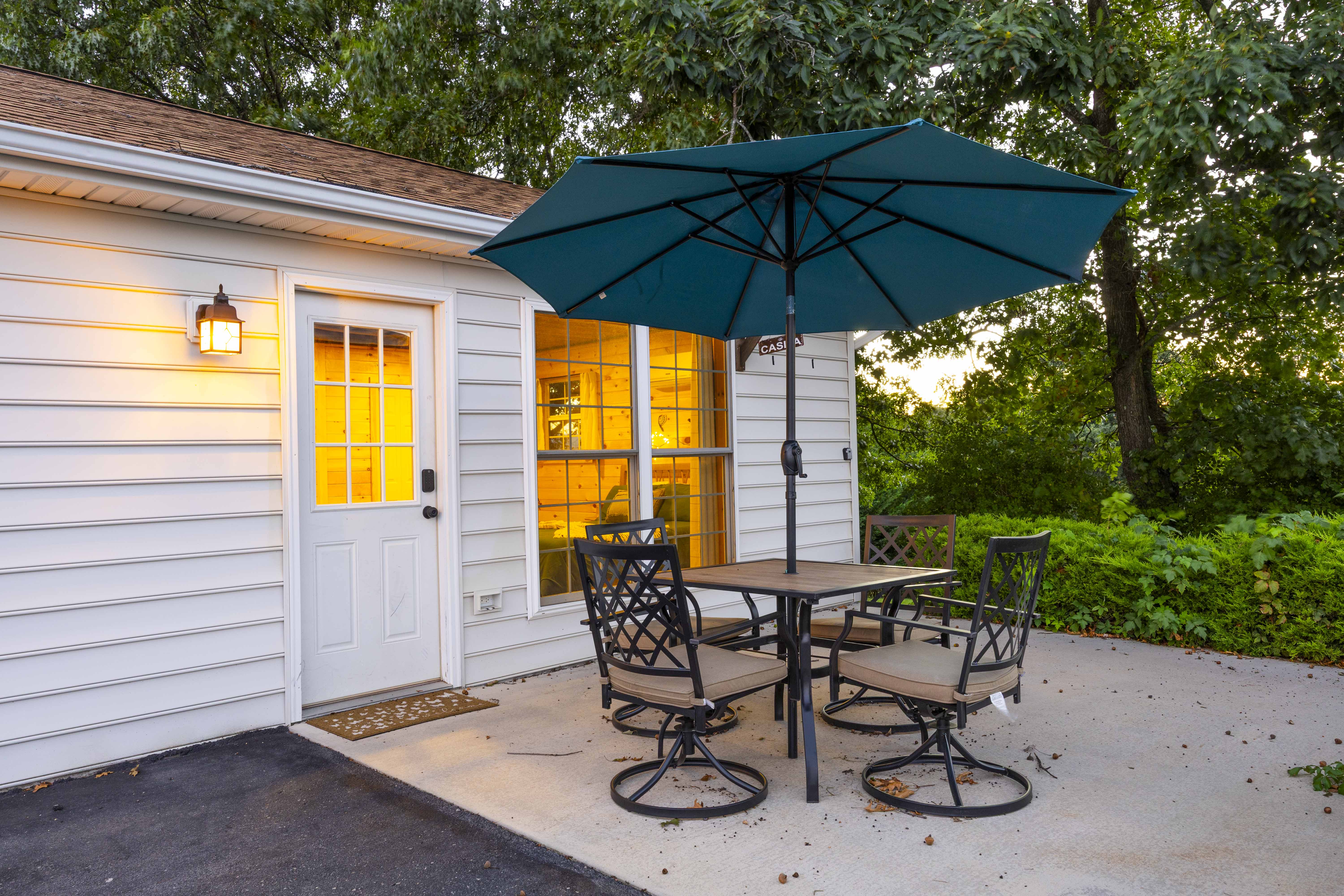Private patio with shaded outdoor dining and serene wooded views