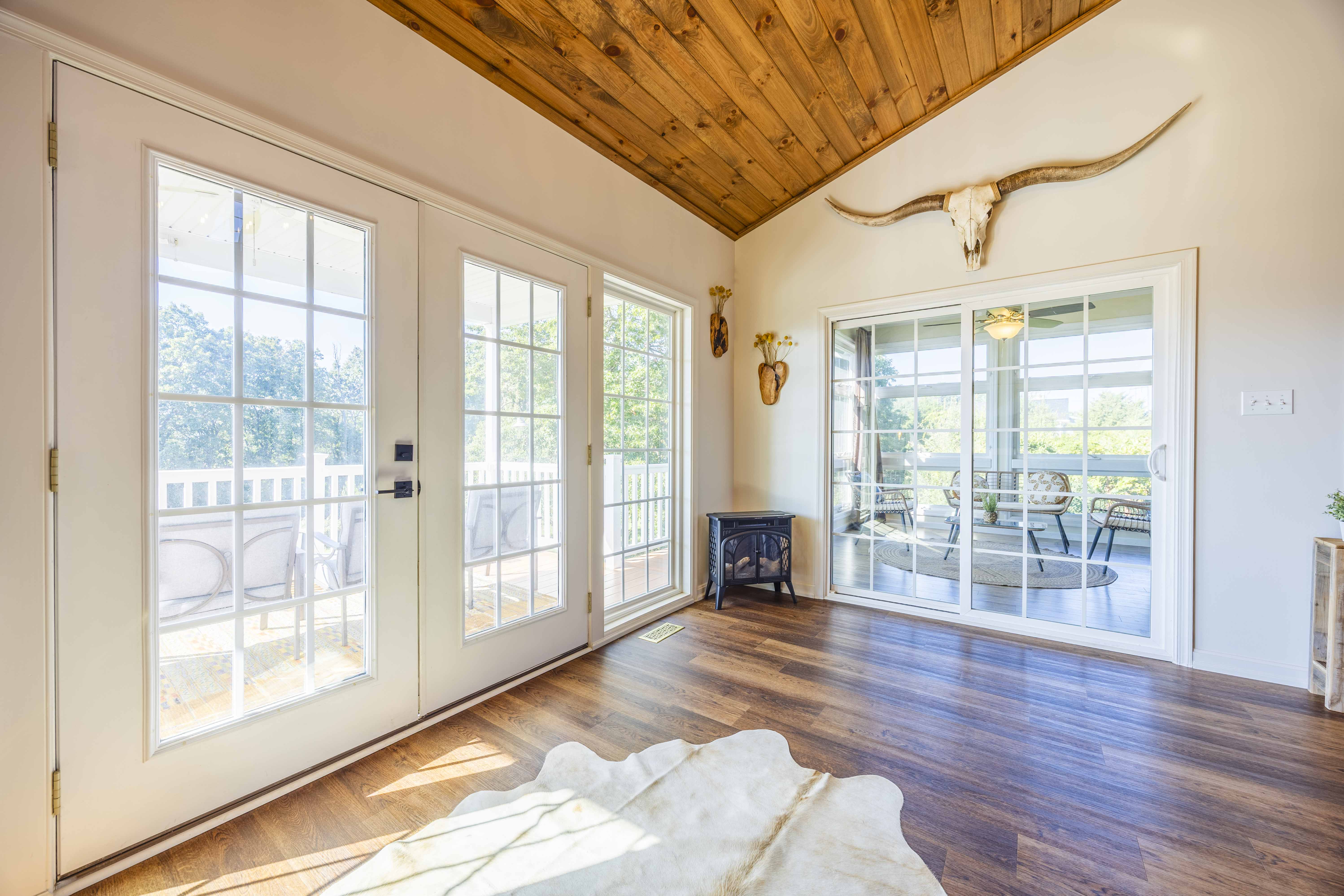 Bright rustic lounge with vaulted wood ceiling and patio access