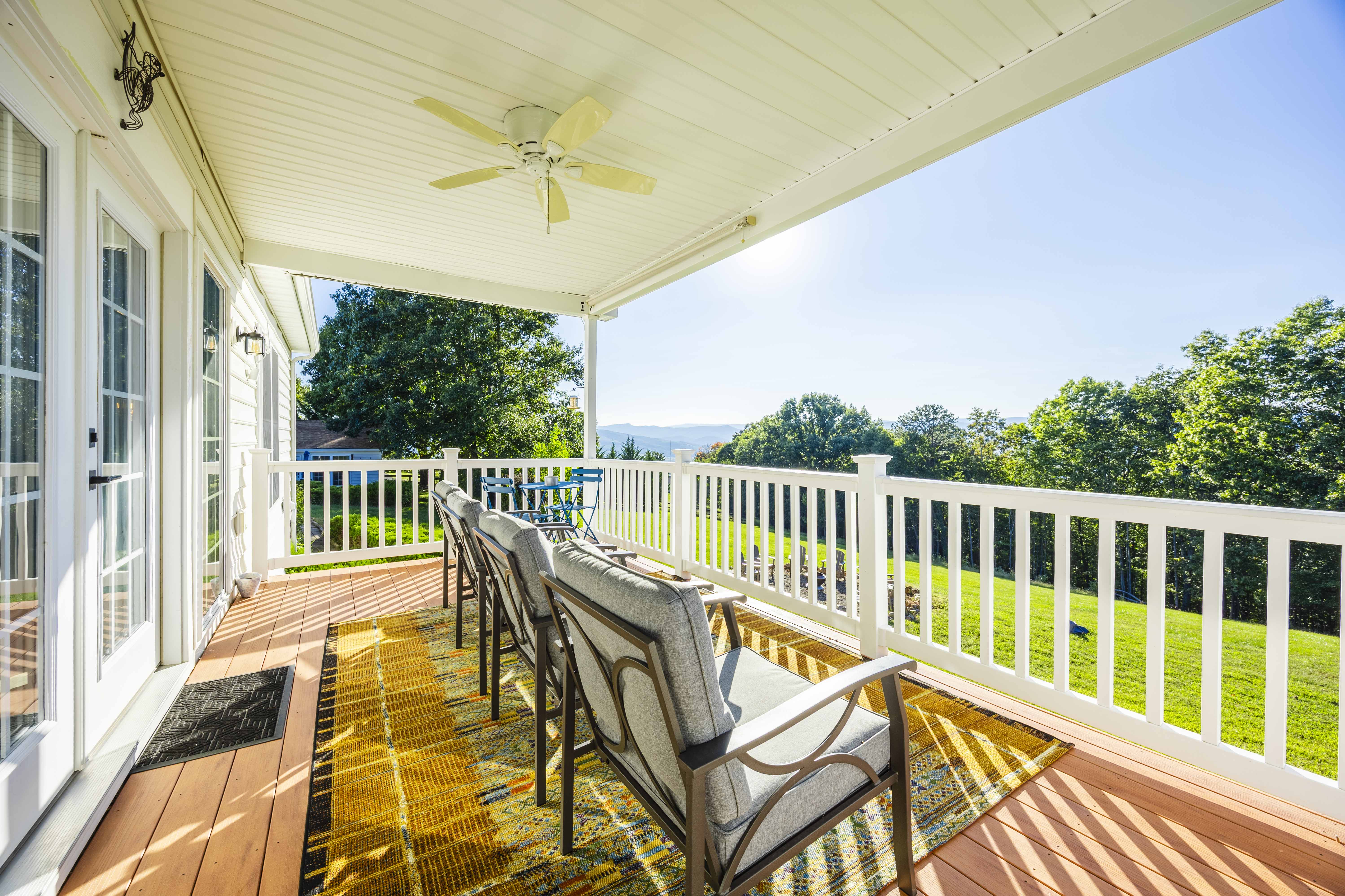 Covered porch with comfy seating and scenic lawn and hill views