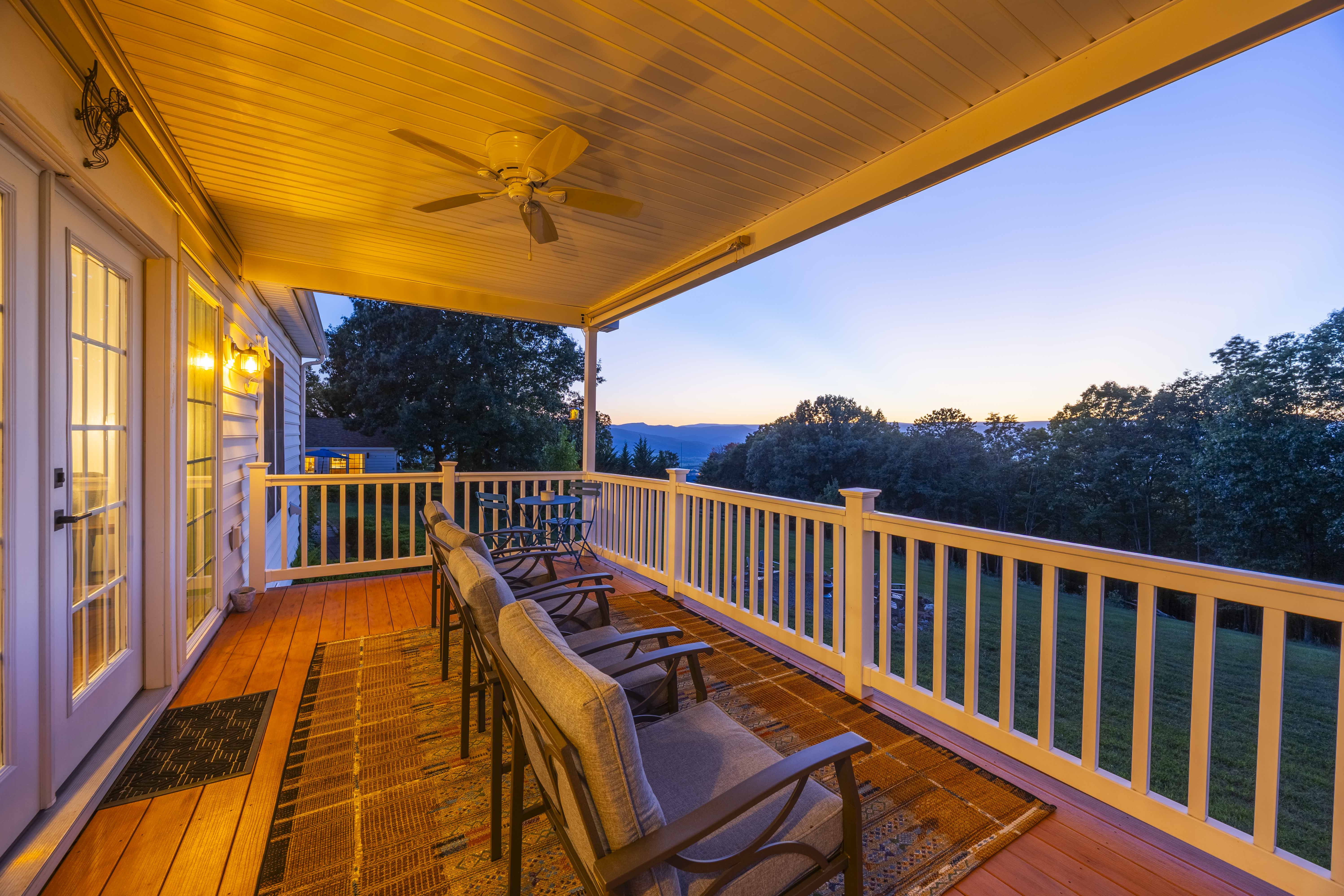 Covered porch with mountain views, cozy seating, and peaceful sunset ambiance