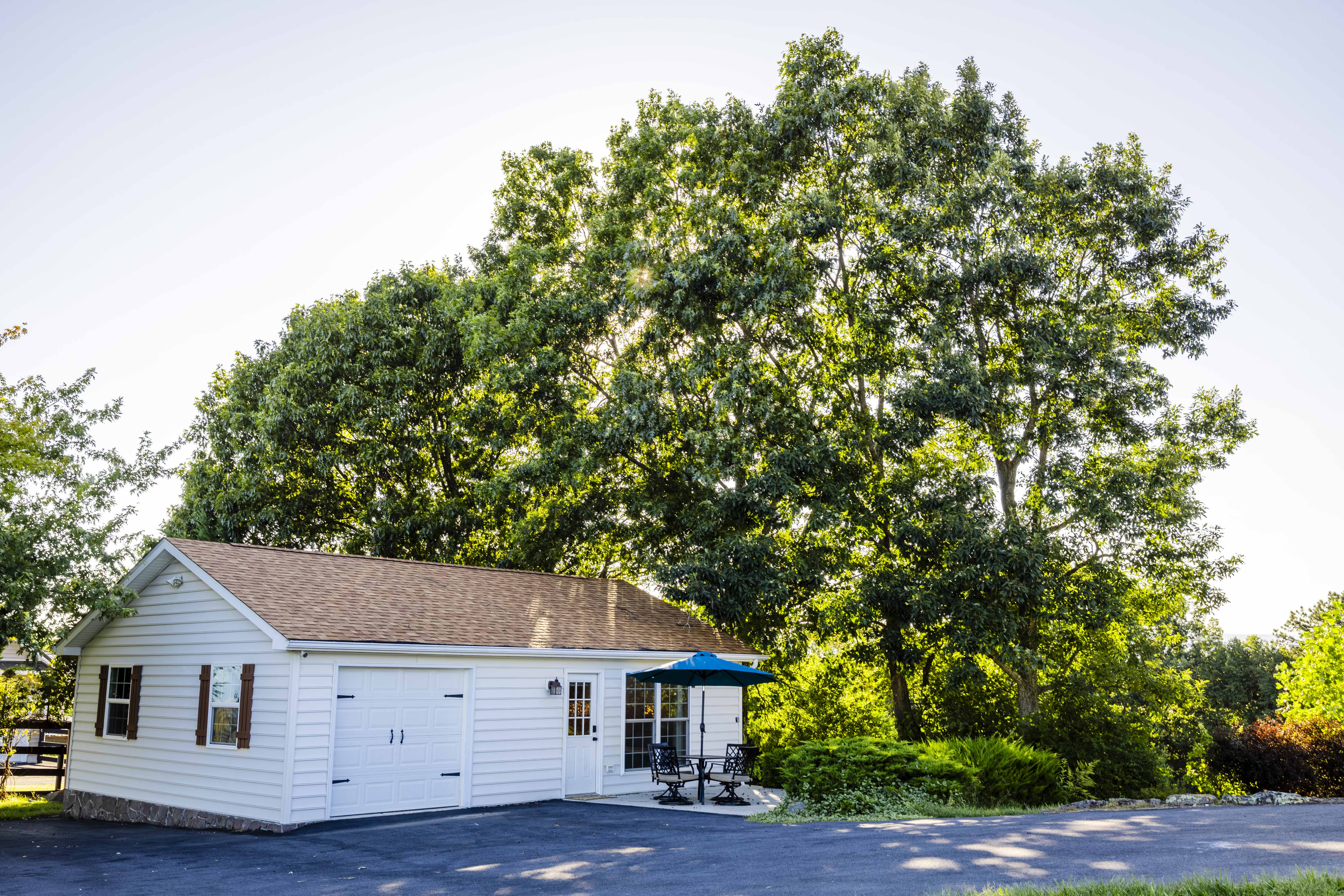 Private tree-lined guest space with patio seating and spacious driveway