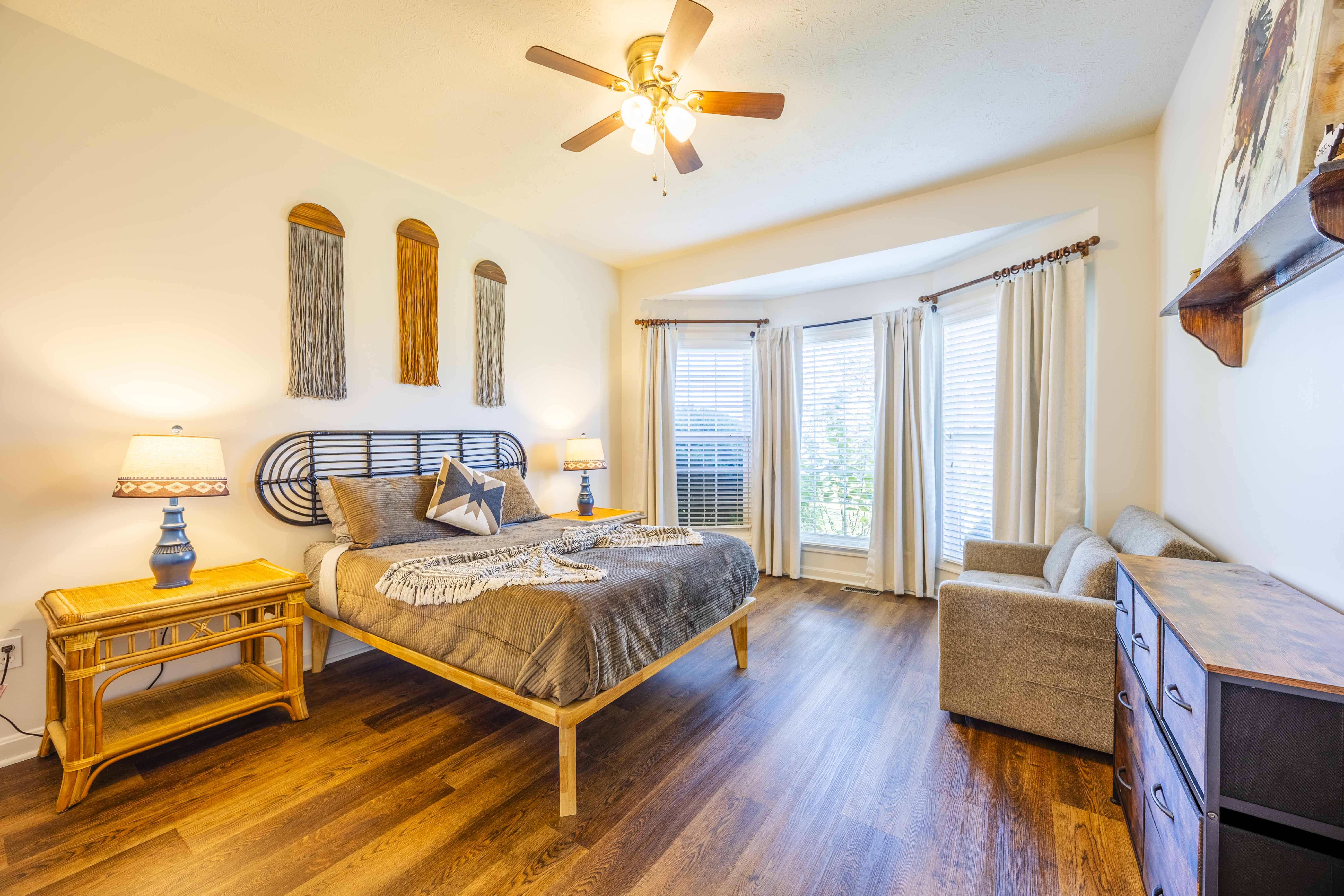 Bright, spacious bedroom with cozy seating and large sunlit windows