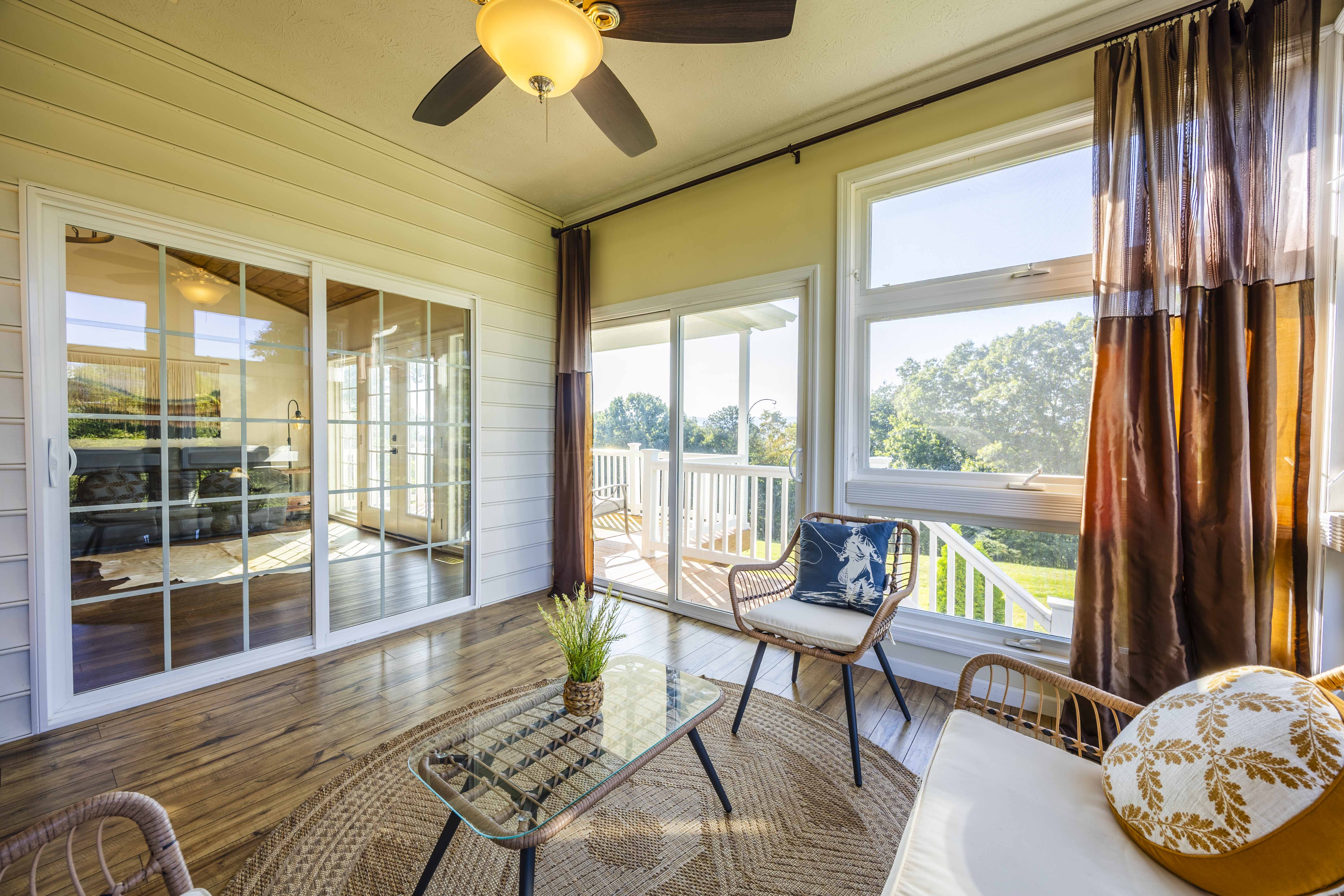 Sunny enclosed porch with deck access and serene outdoor views