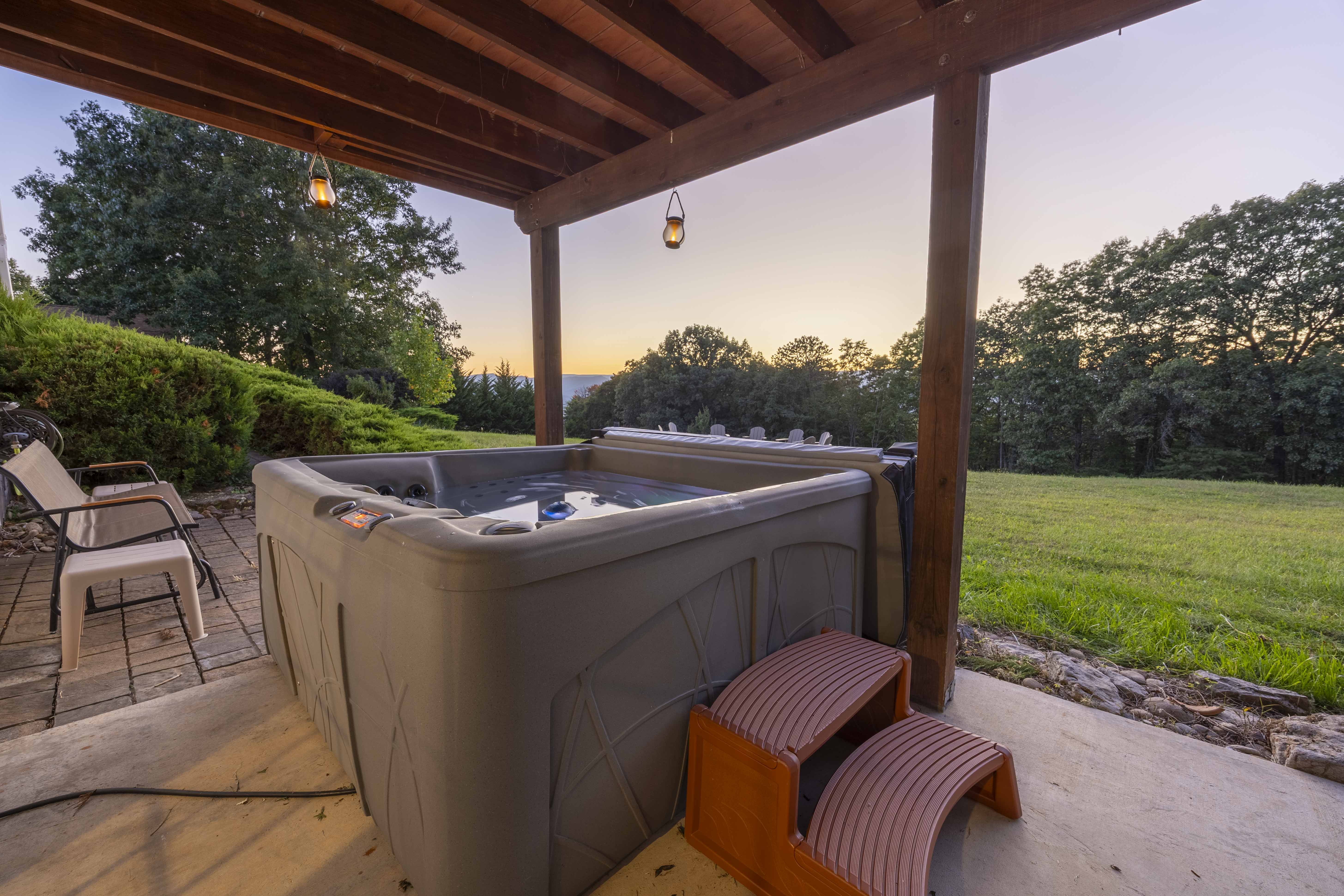 Covered hot tub patio with sunset views and a peaceful private yard